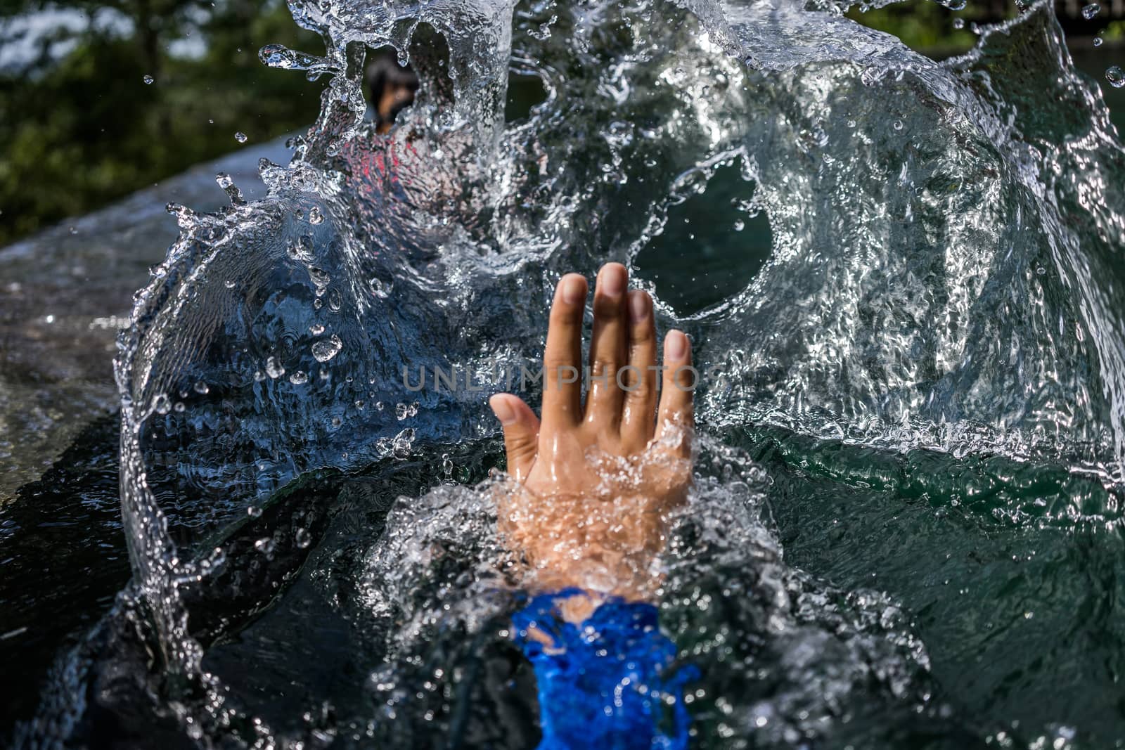 A shot of a person's hand pushing the water making a big splash.