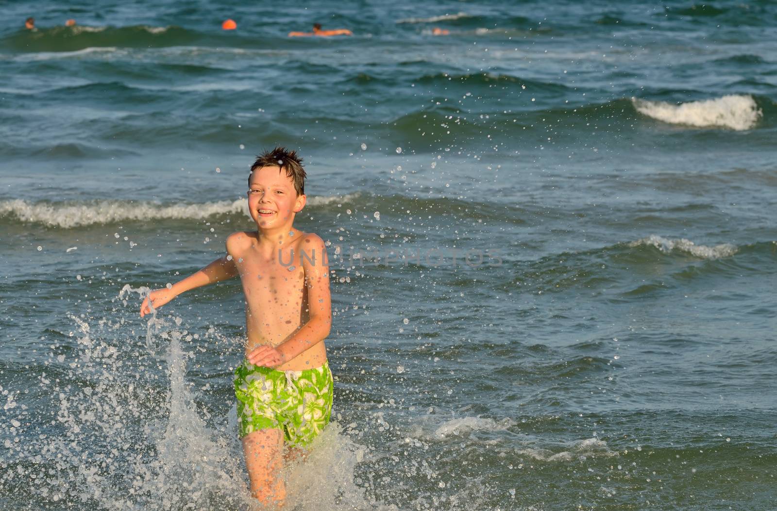 boy running through the waves at the beach