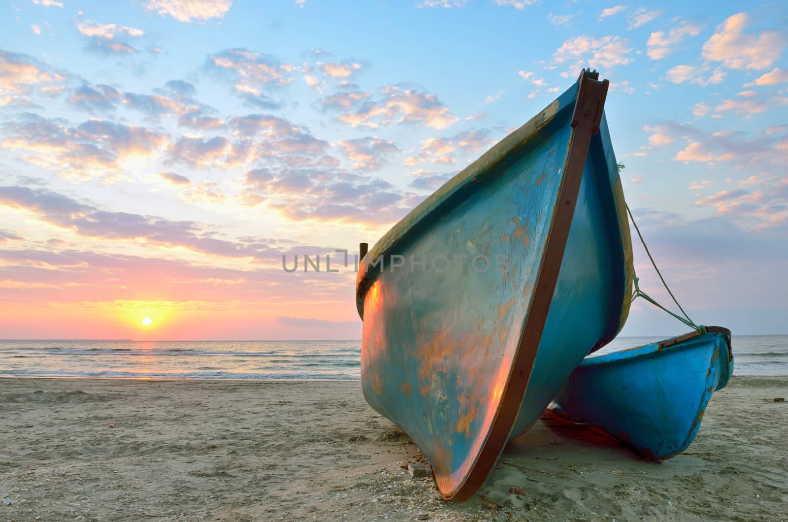 Beautiful sunrise over an two wooden fishing boats