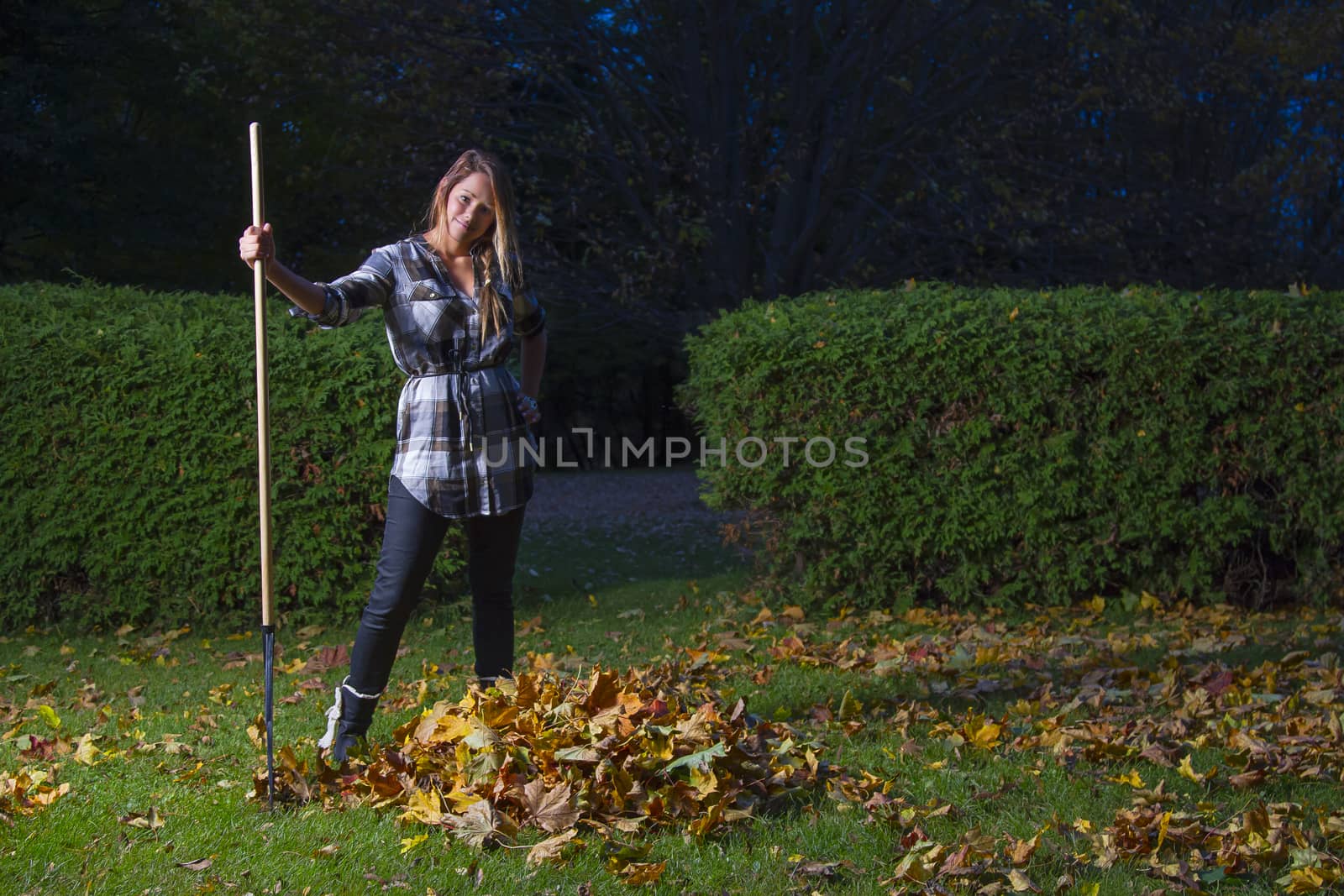 young woman in her twenties, raking leaves