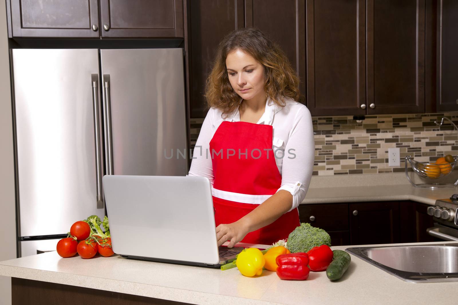 woman searching recipes online while cooking raw vegetables