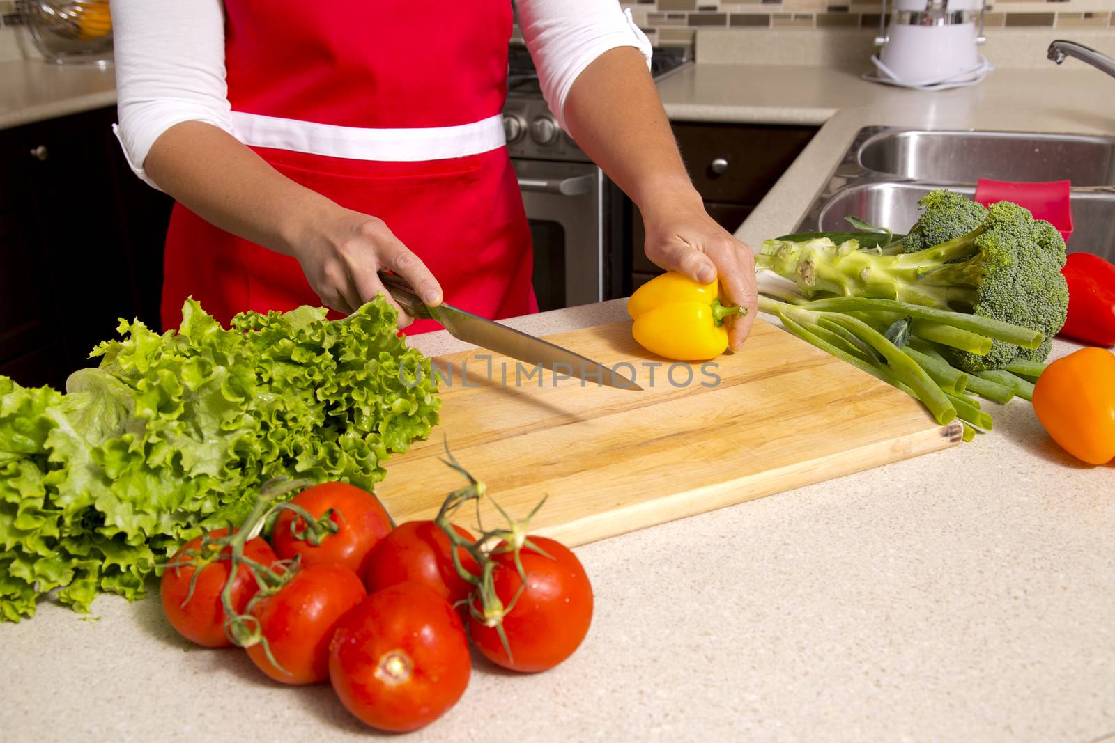 caucasian woman about to cut raw vegetables  on the kitchen