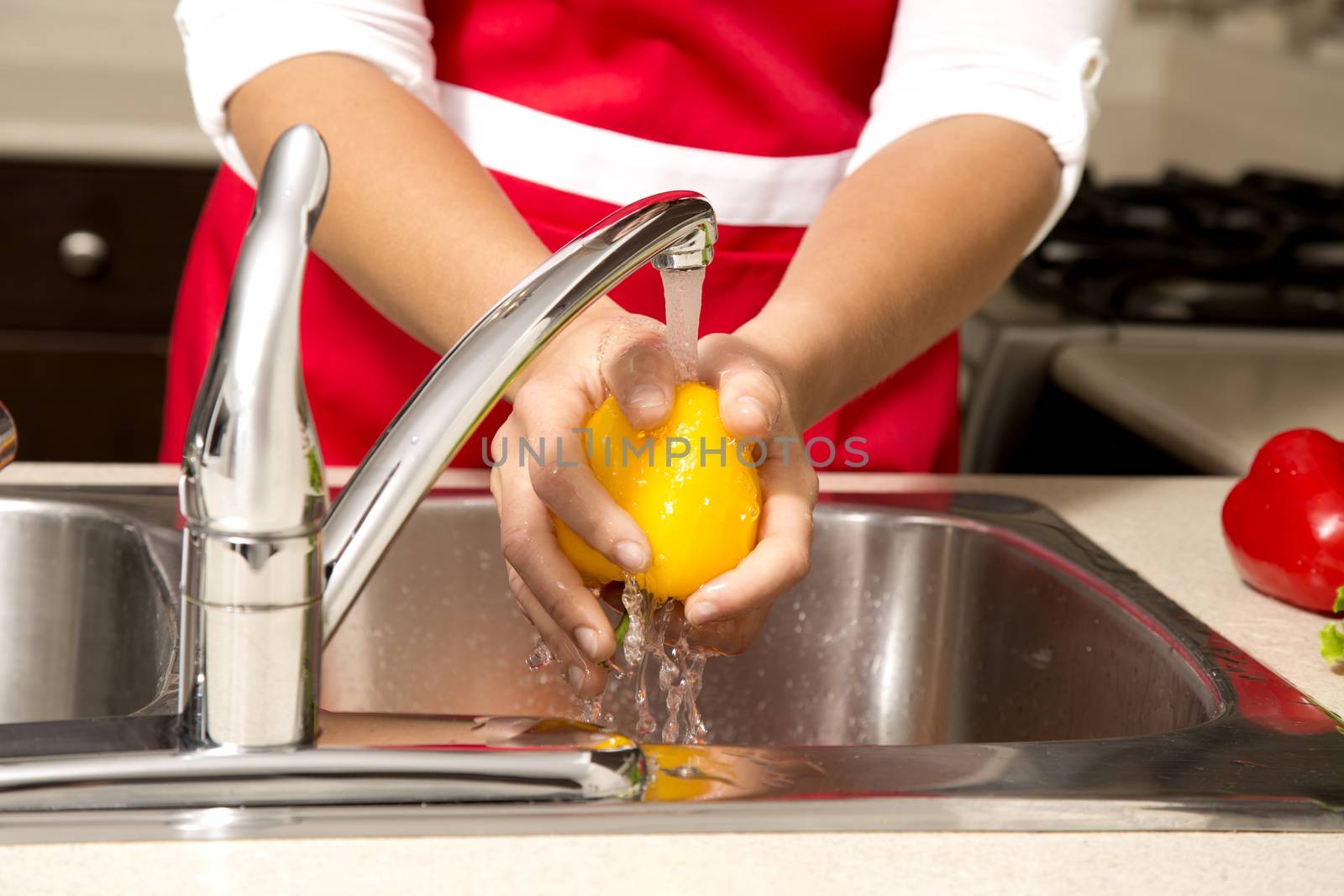 woman washing vegetables in the sink home kitchen