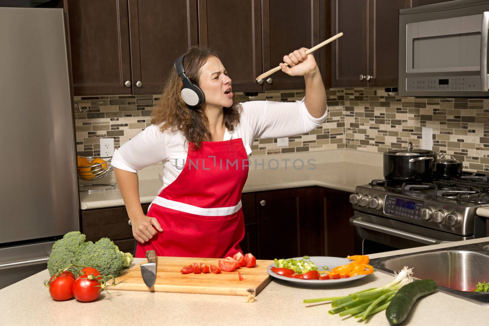 woman in the kitchen listening to music and singing