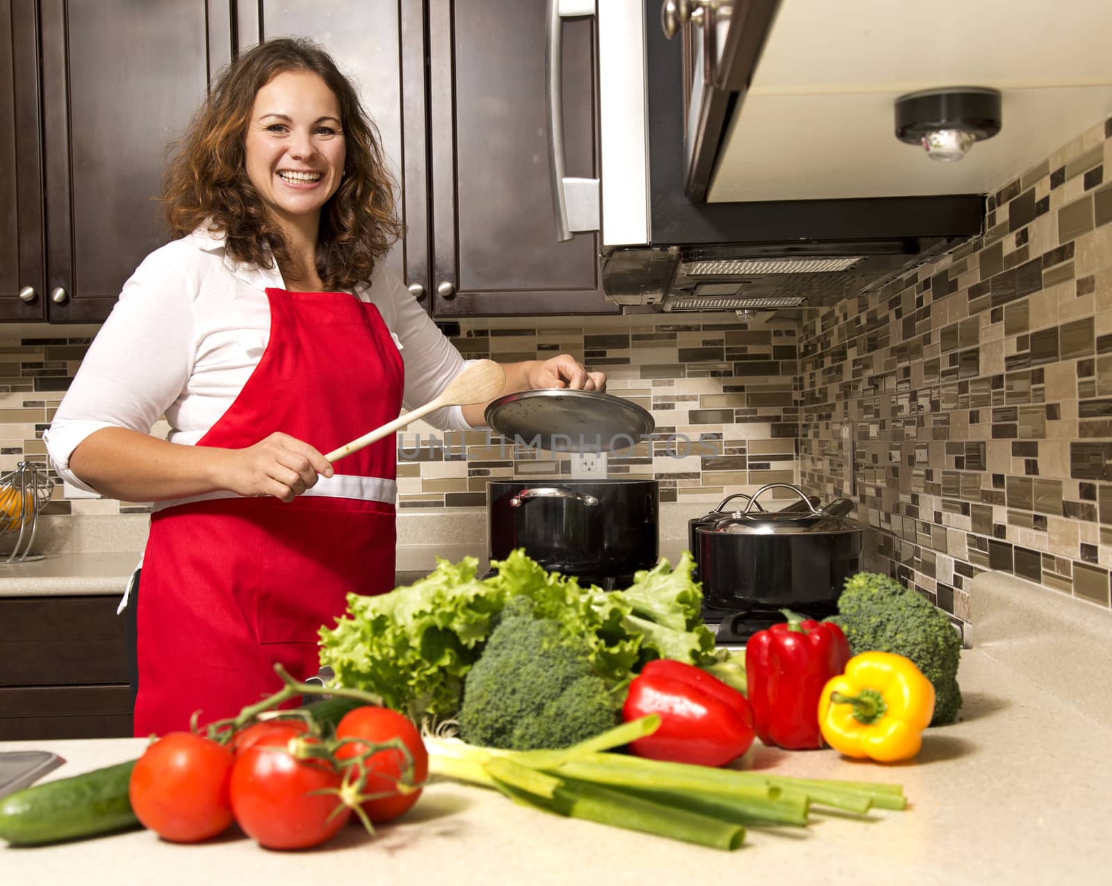 woman cooking with raw vegetables in the kitchen