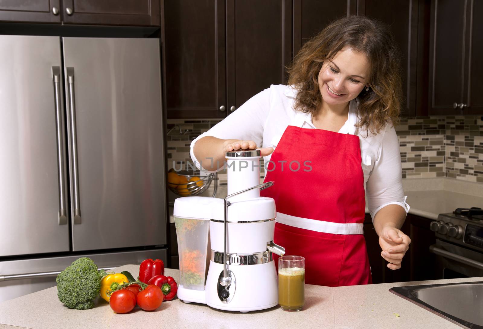 woman making juice from raw vegetables in the kitchen