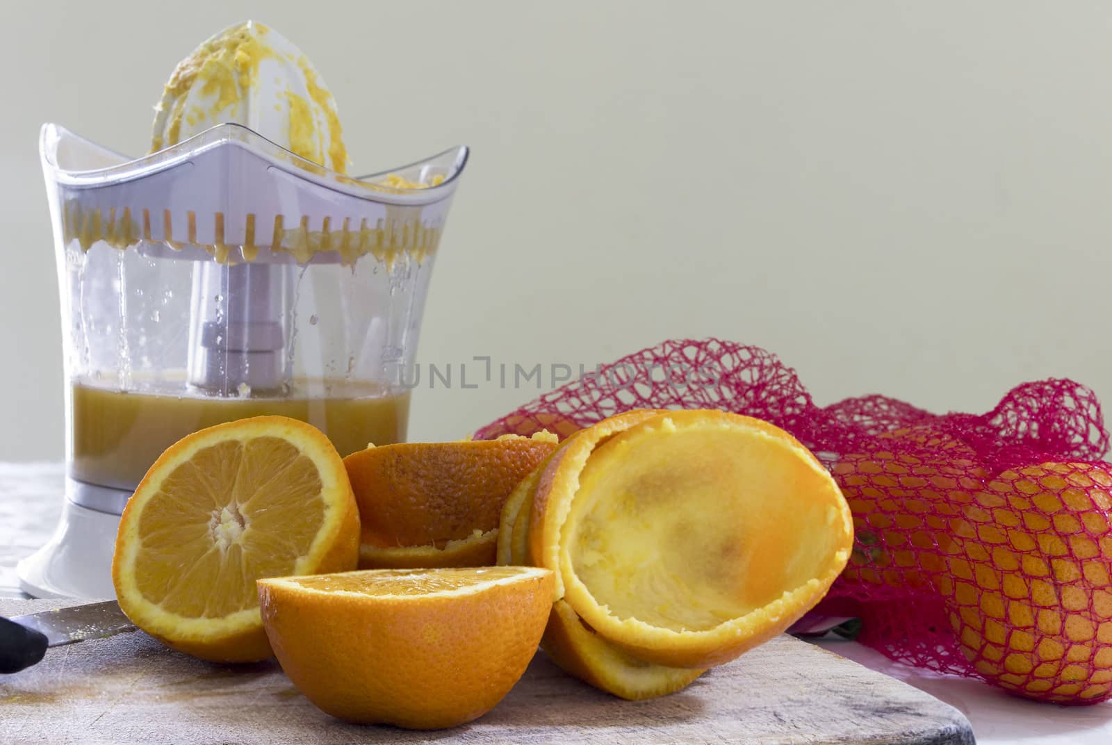 Orange juice, juicer and orange fruits on the table