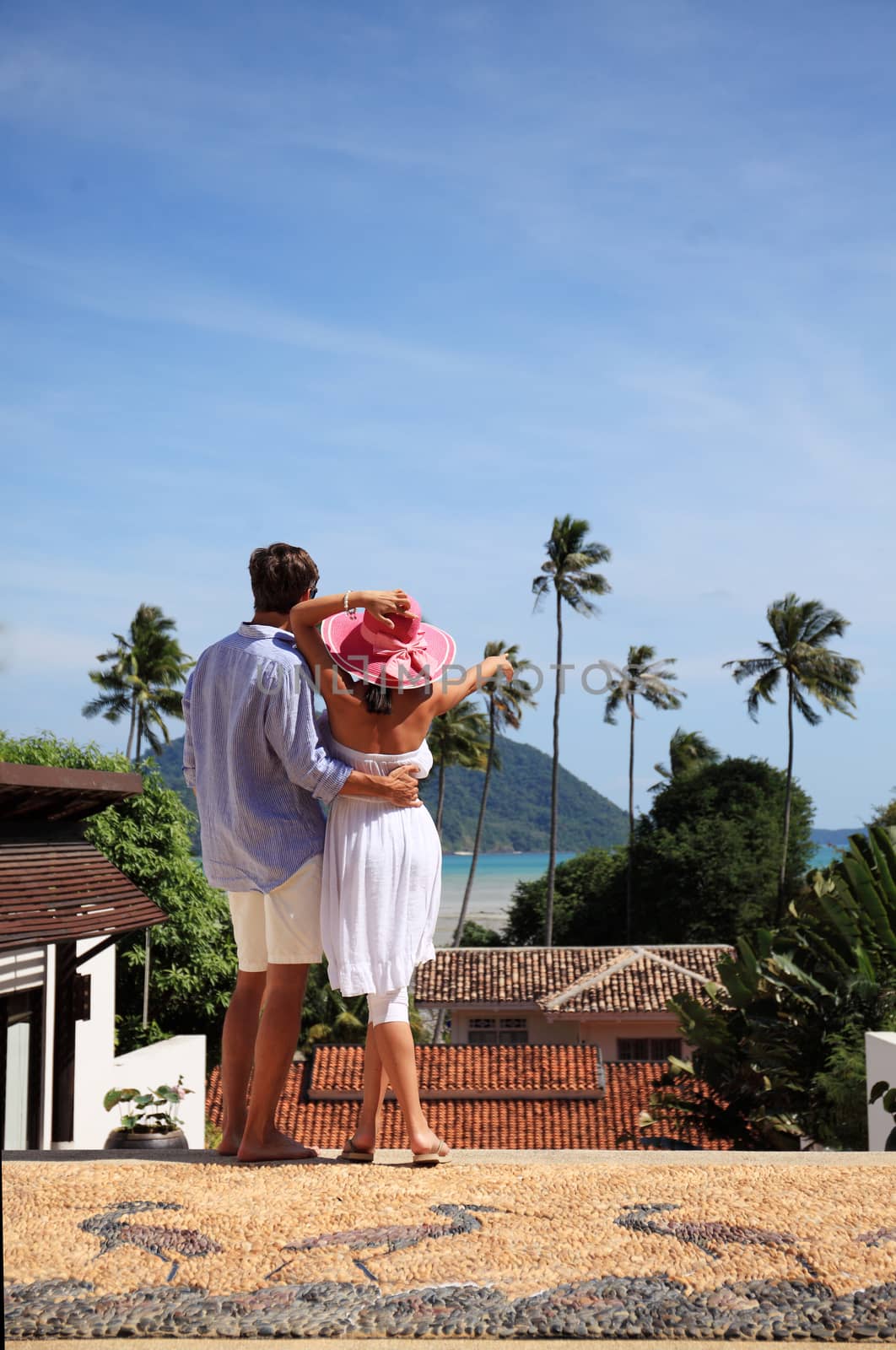 Young couple look at tourist resort and sea