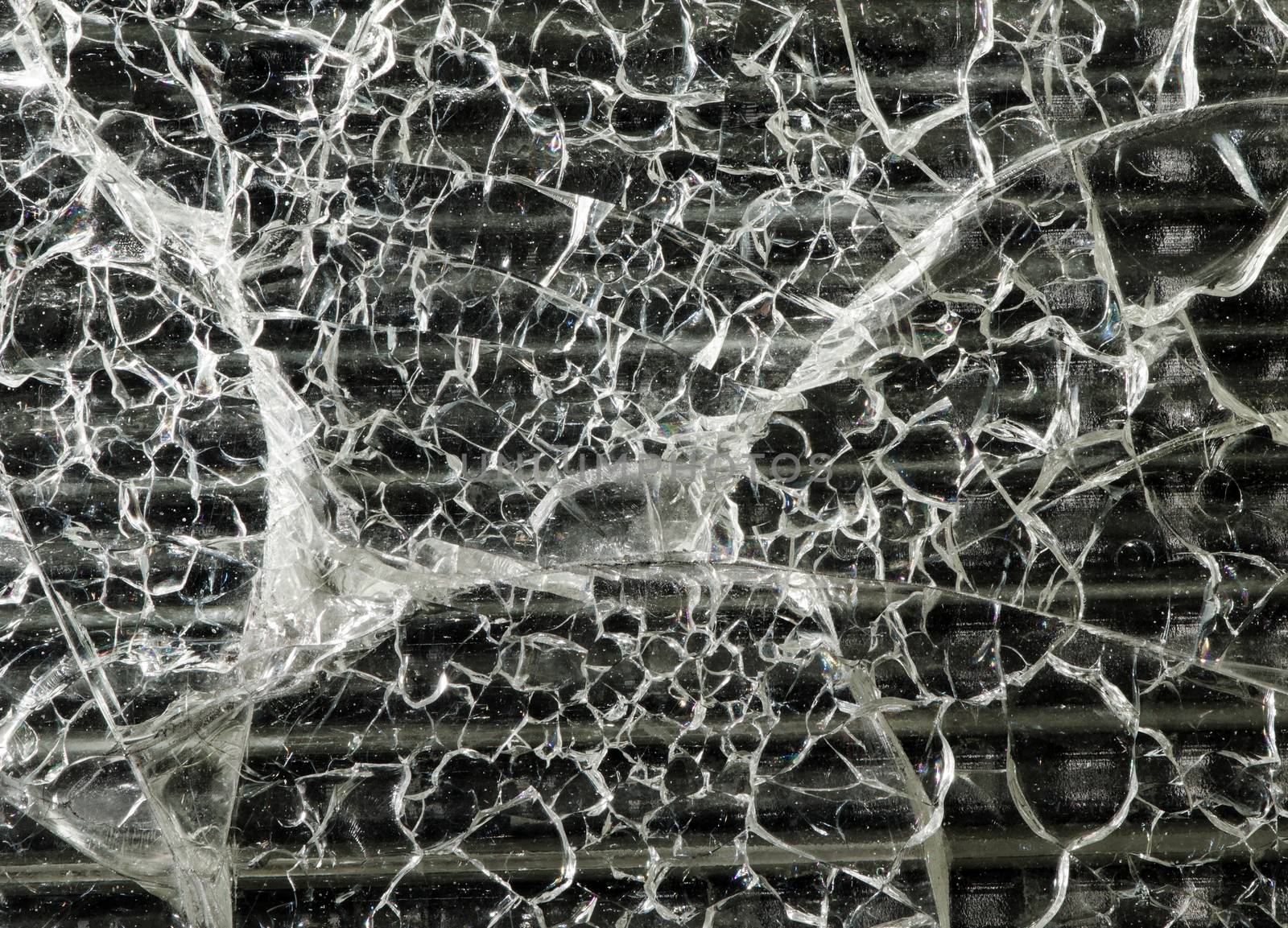 Broken glass sheet isolated against black background.