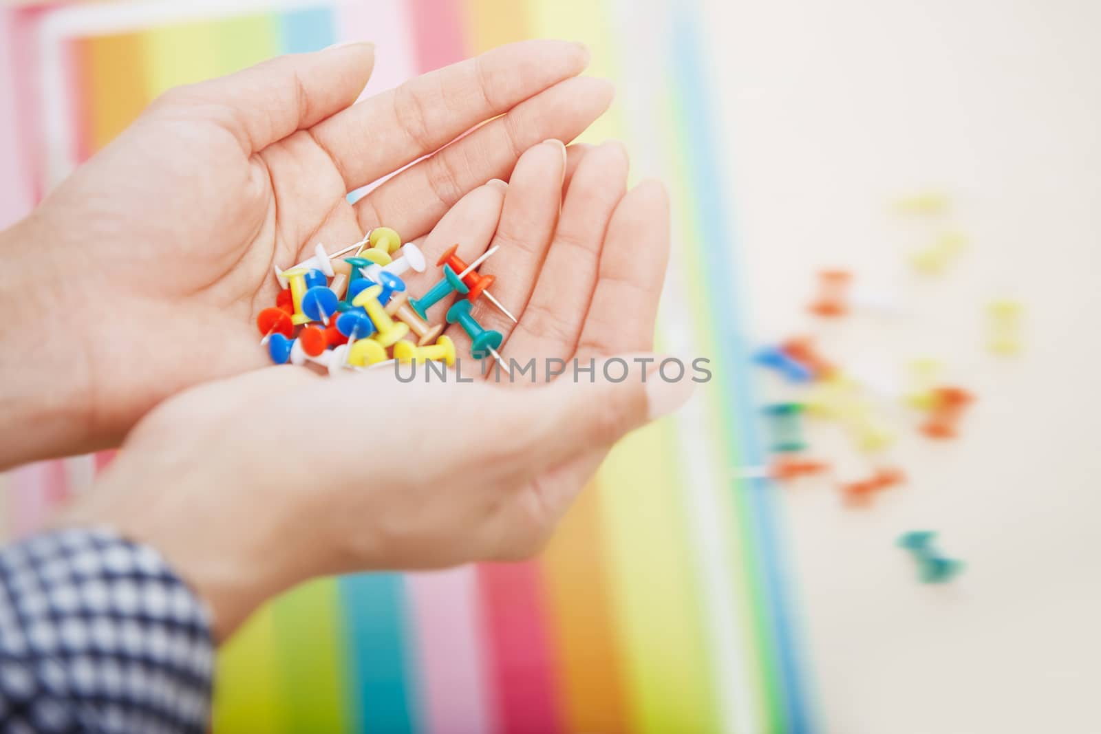 Hands with colorful pushpins by Novic