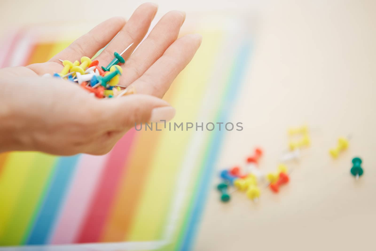 Hand with colorful pushpins by Novic