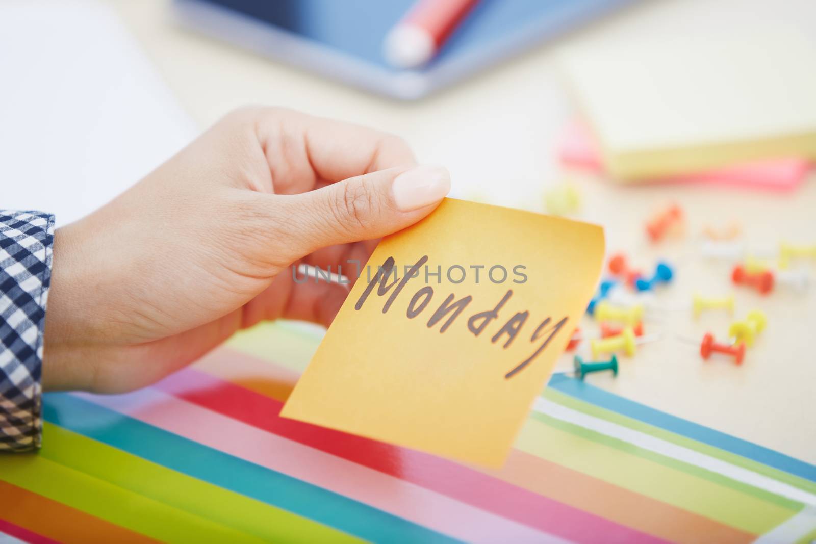 Human hand holding adhesive note with Monday text