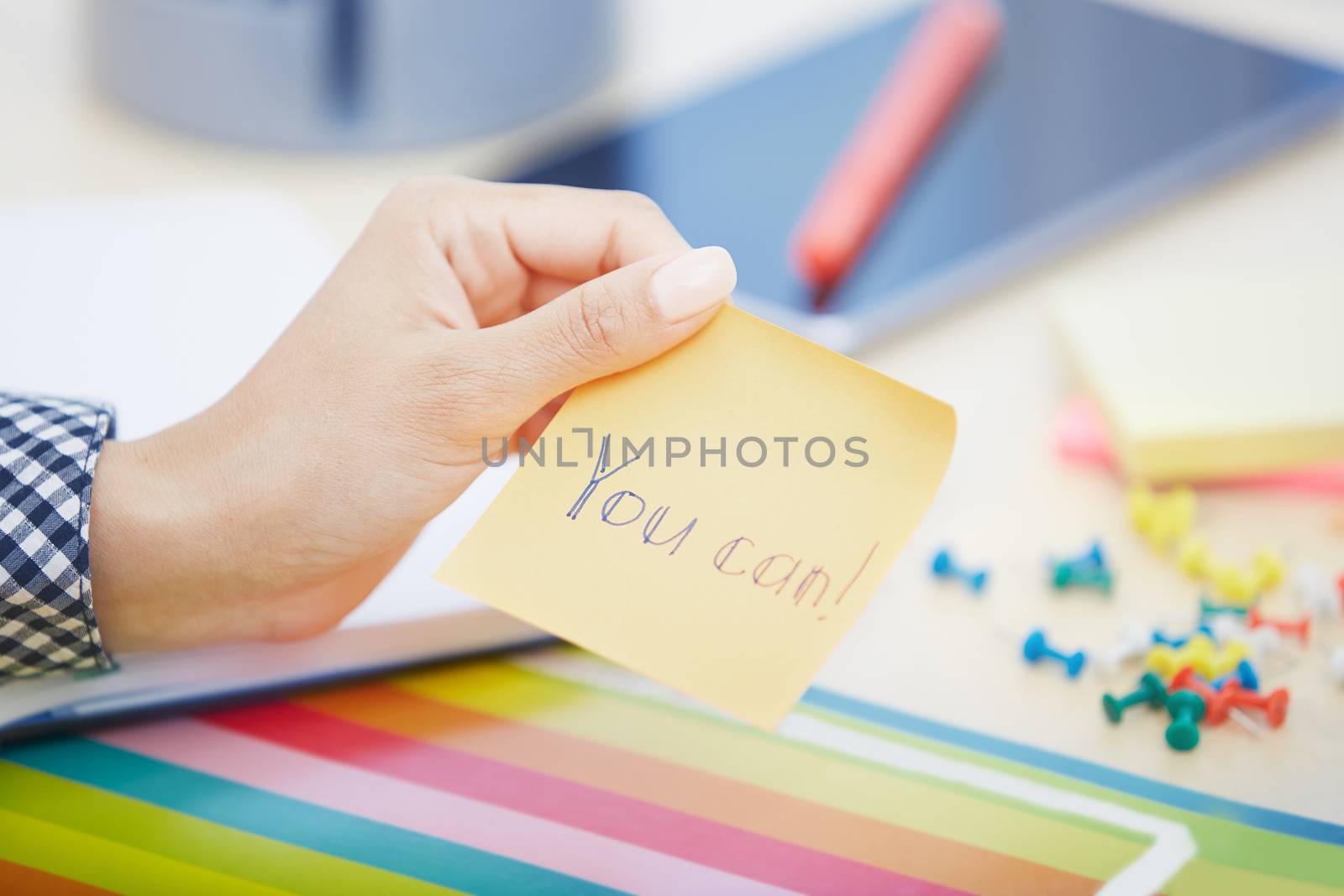 Human hand holding adhesive note with You can text