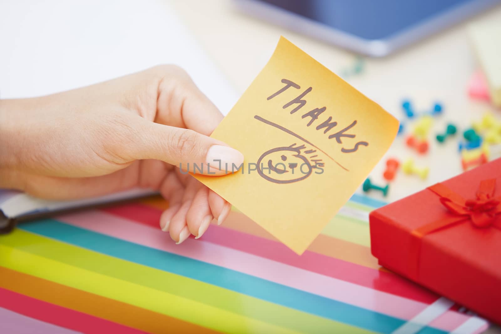 Human hand holding adhesive note with Thanks text