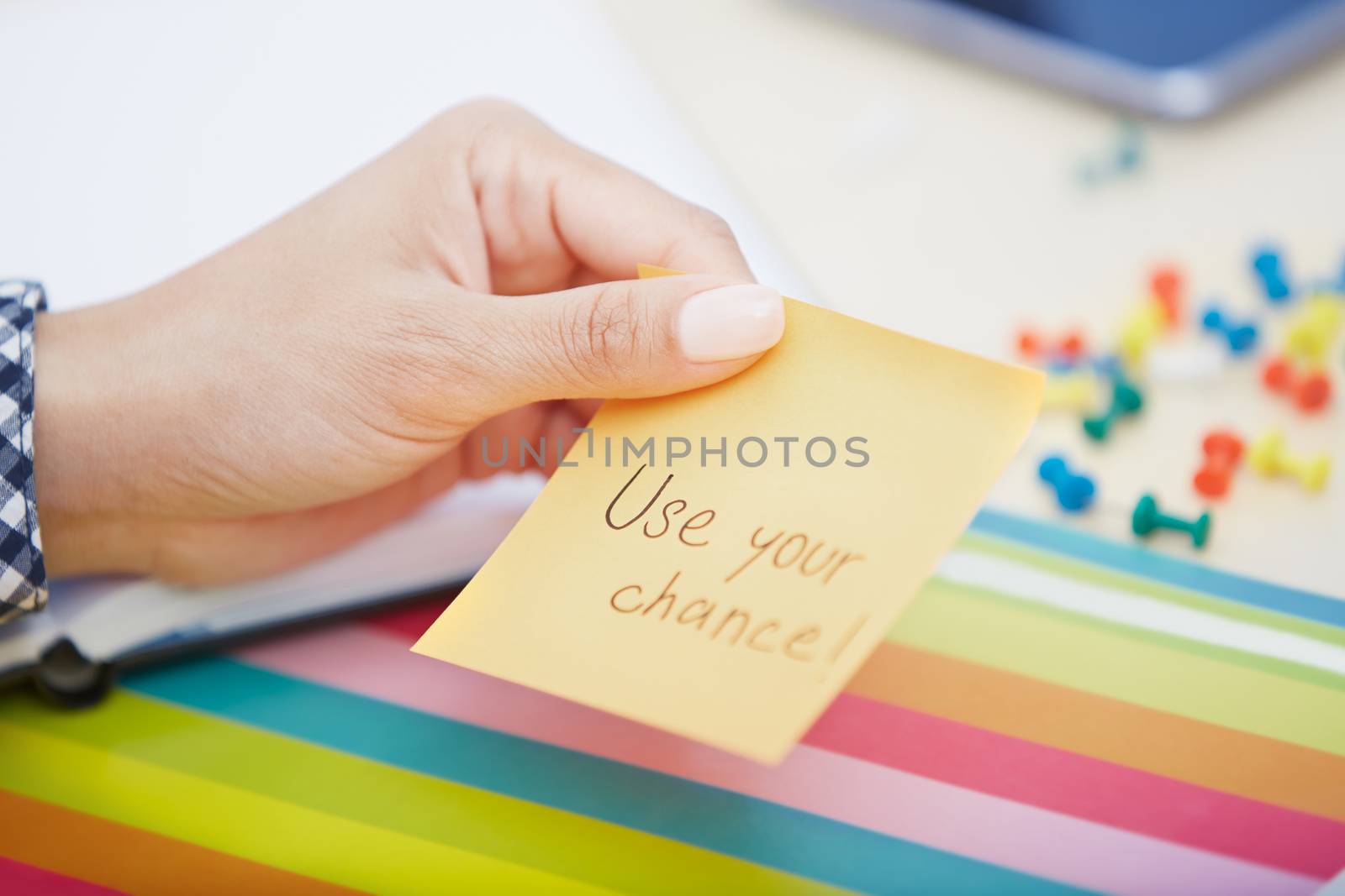 Human hand holding adhesive note with Use your chance text