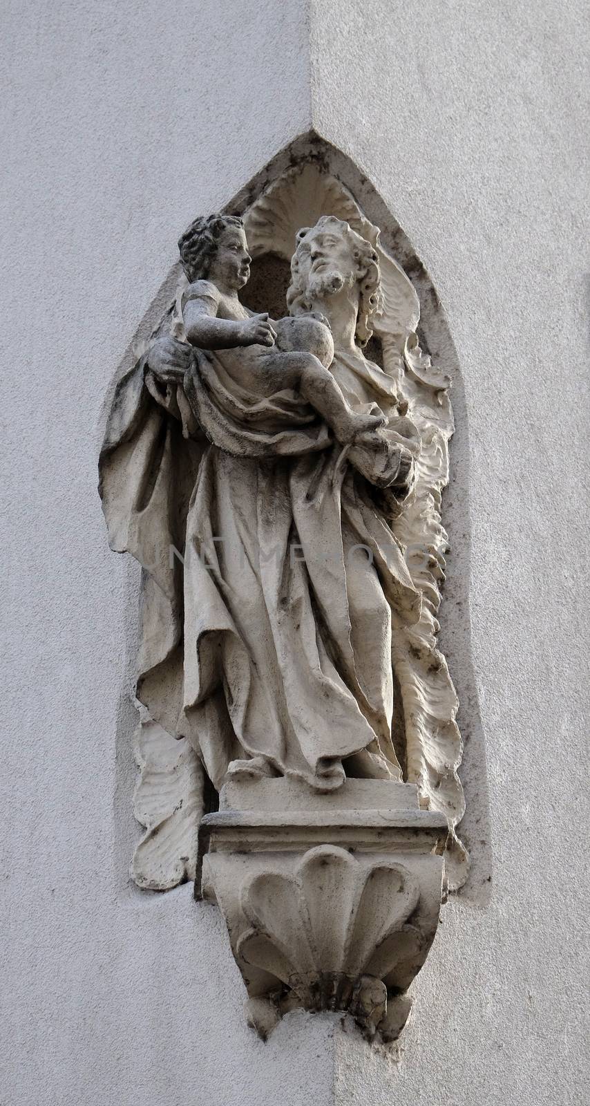 Saint Joseph holding baby Jesus, statue on the house facade in Graz, Styria, Austria