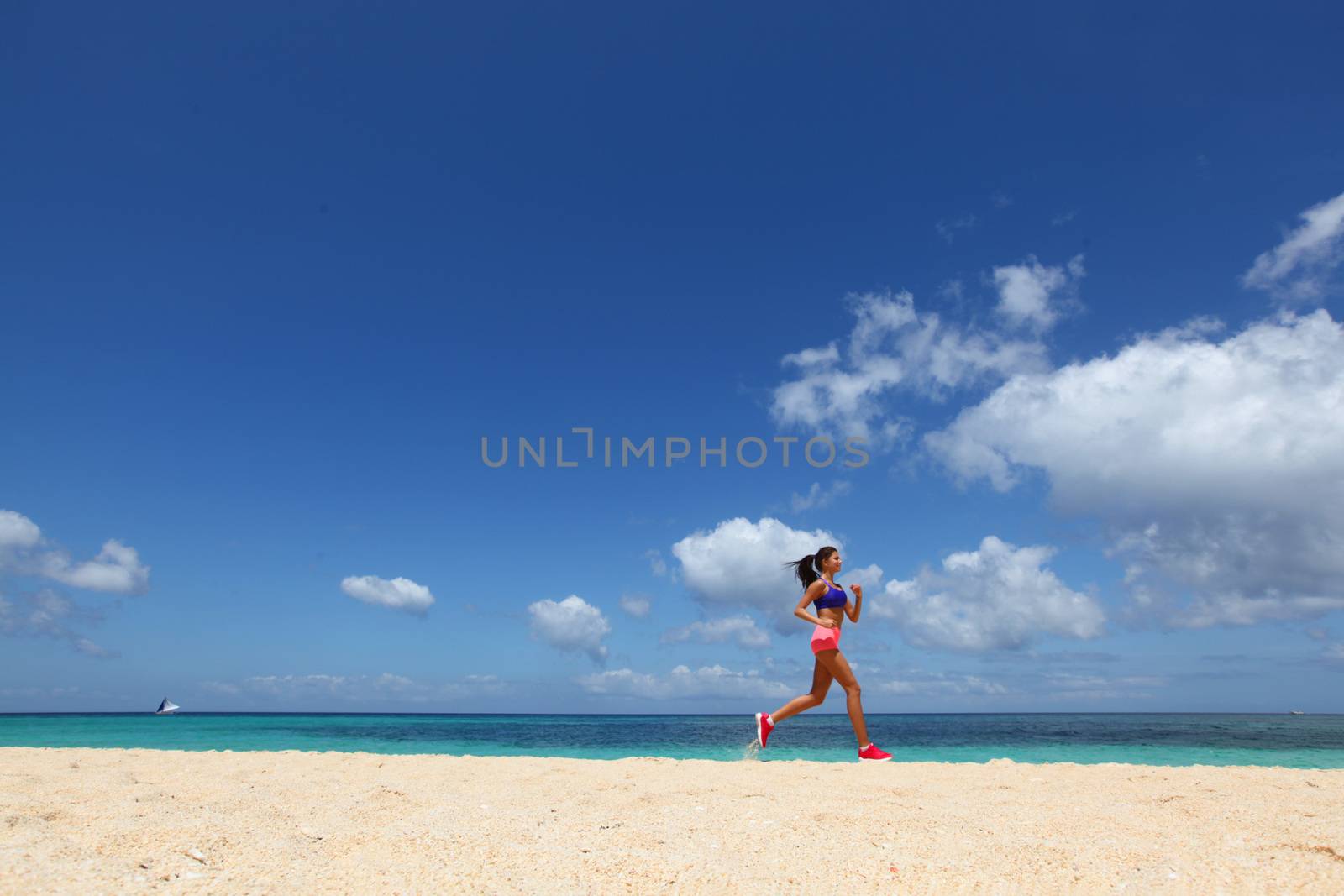 Running woman jogging on beach and sea on background
