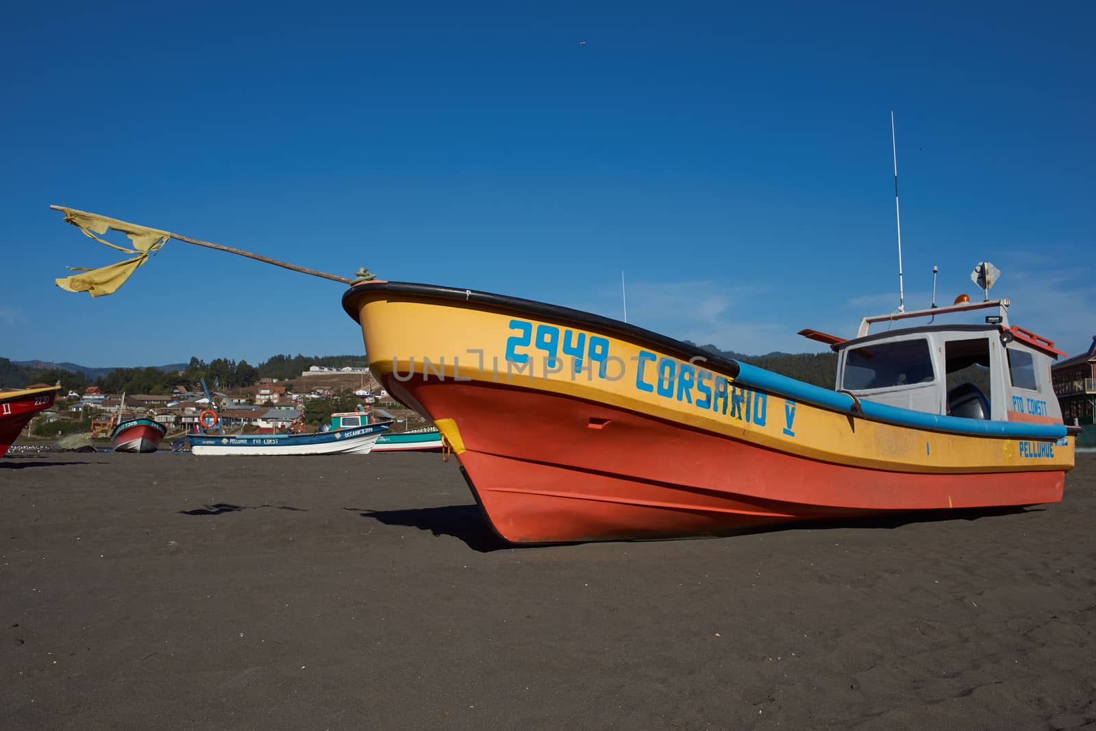 Colourful fishing boat and fishing nets on the beach in the small fishing village of Curanipe in the Maule Region of Chile.