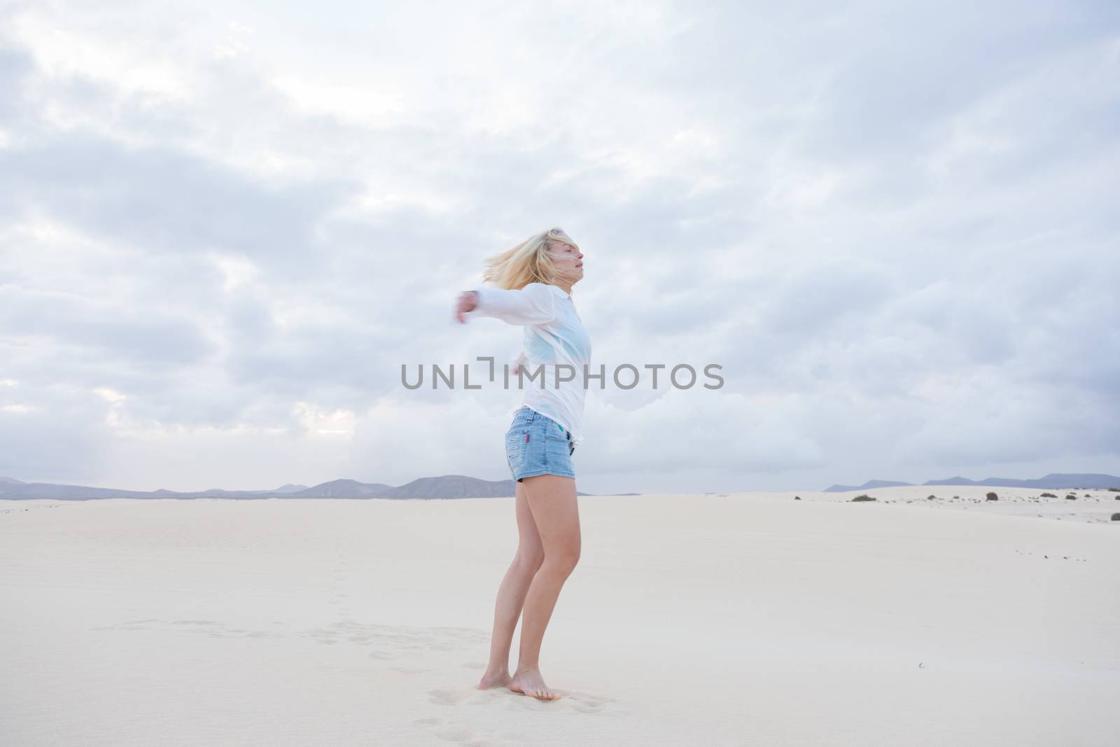 Relaxed woman enjoying freedom feeling happy at beach in the morning. Serene relaxing woman in pure happiness and elated enjoyment with arms outstretched.