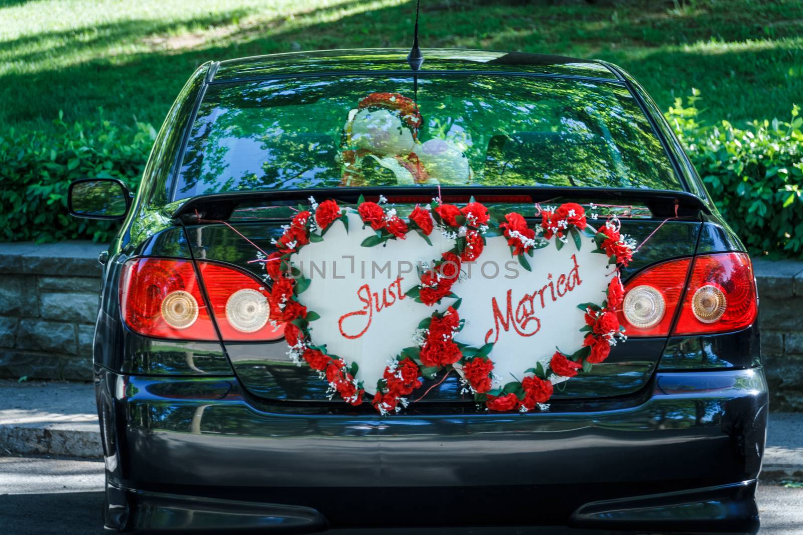 A "Just Married" sign at the back of a car waiting for the newlywed couple