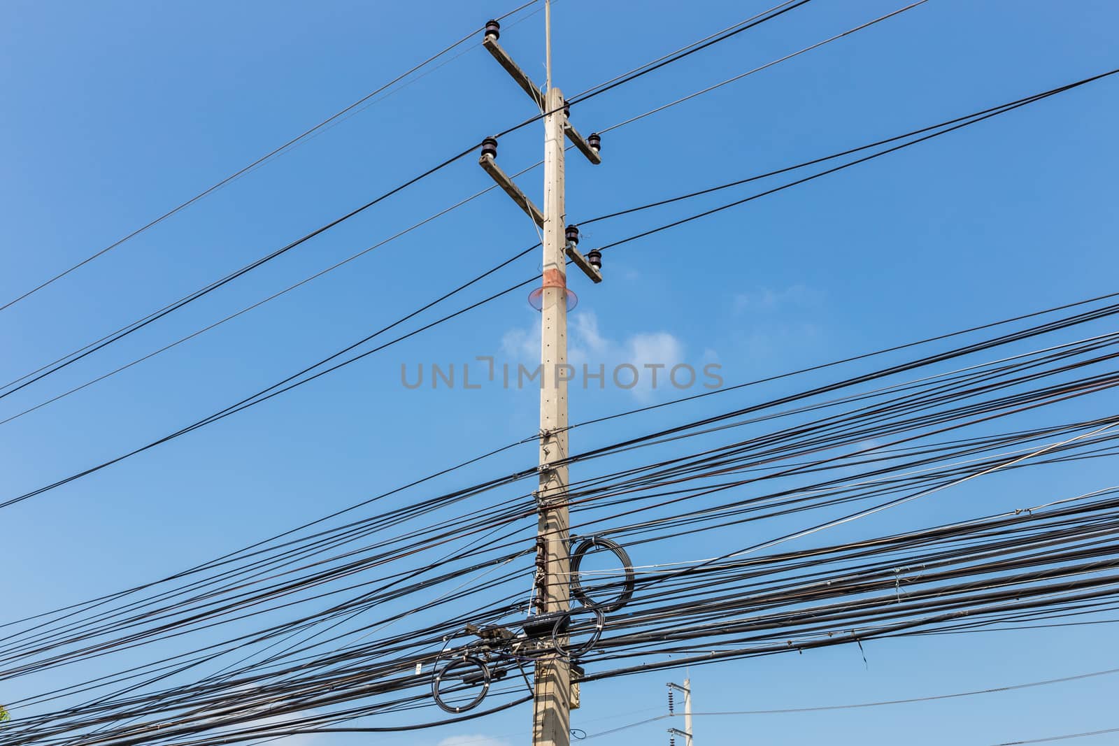 Electric pole power lines and messy wires with blue sky,Thailand