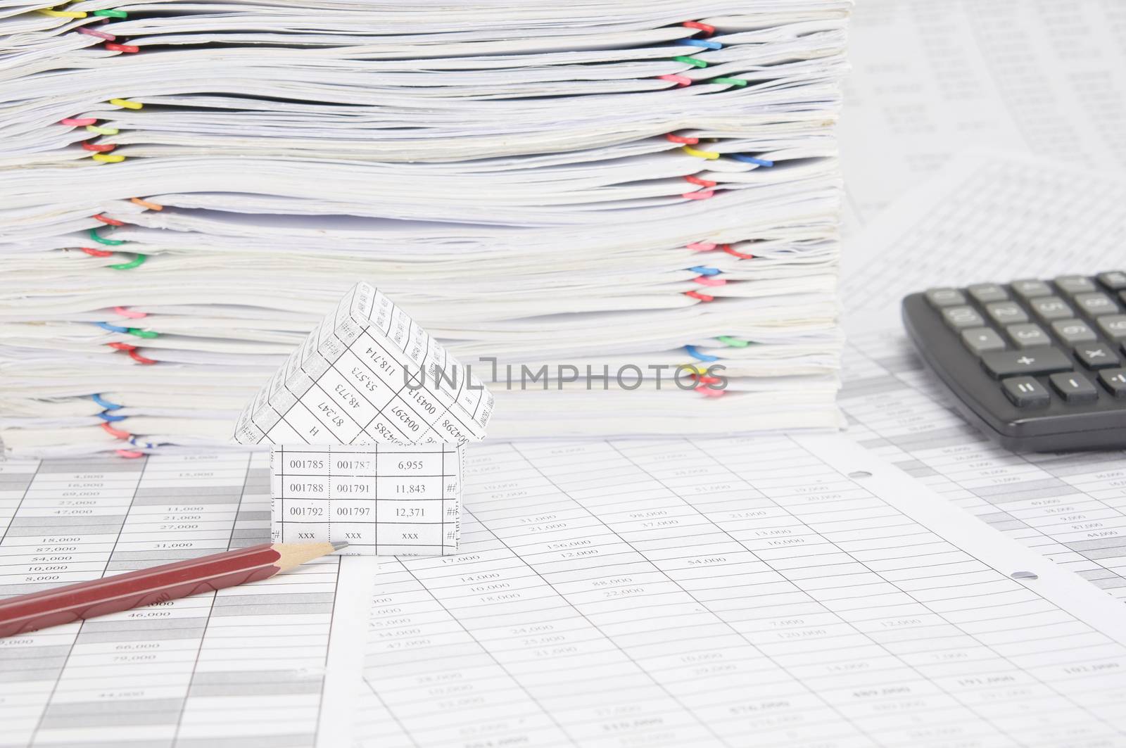 Pencil and house on finance account have calculator and overload of paperwork with colorful paperclip as background.