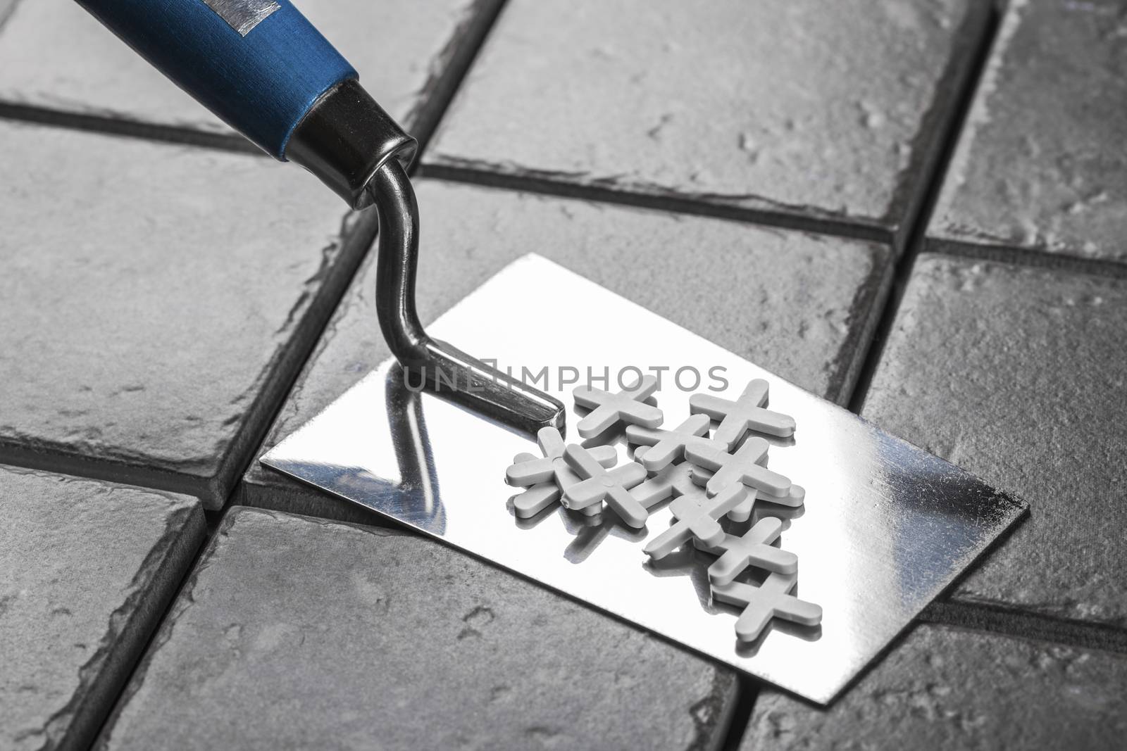 the trowel closeup on a background of ceramic tile