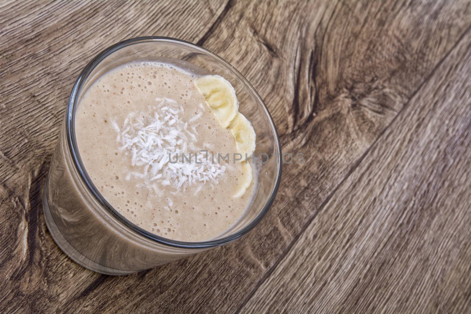 Chocolate drink with coconut and banana on a wooden backhģround
