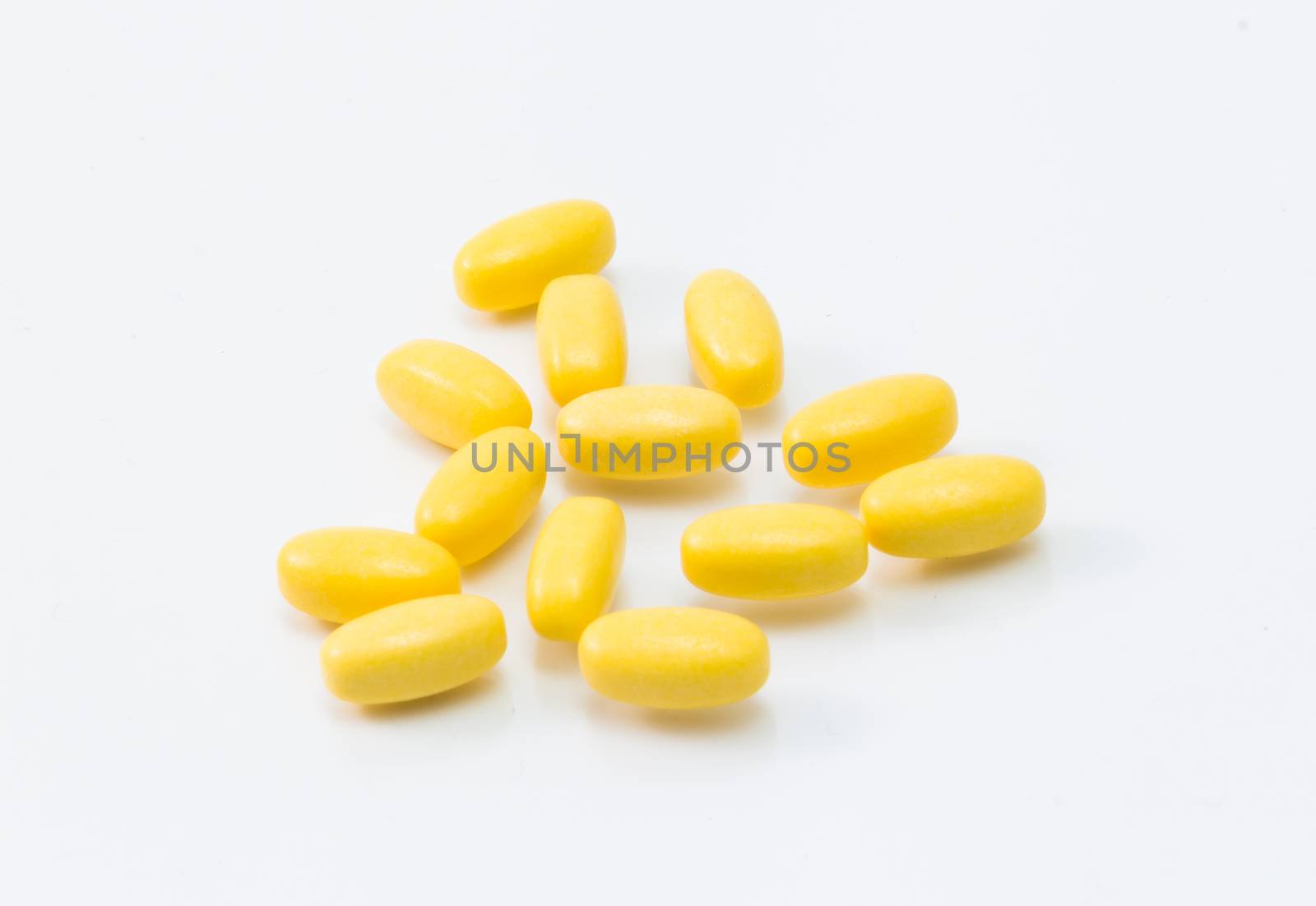 yellow pill isolated on white background close up