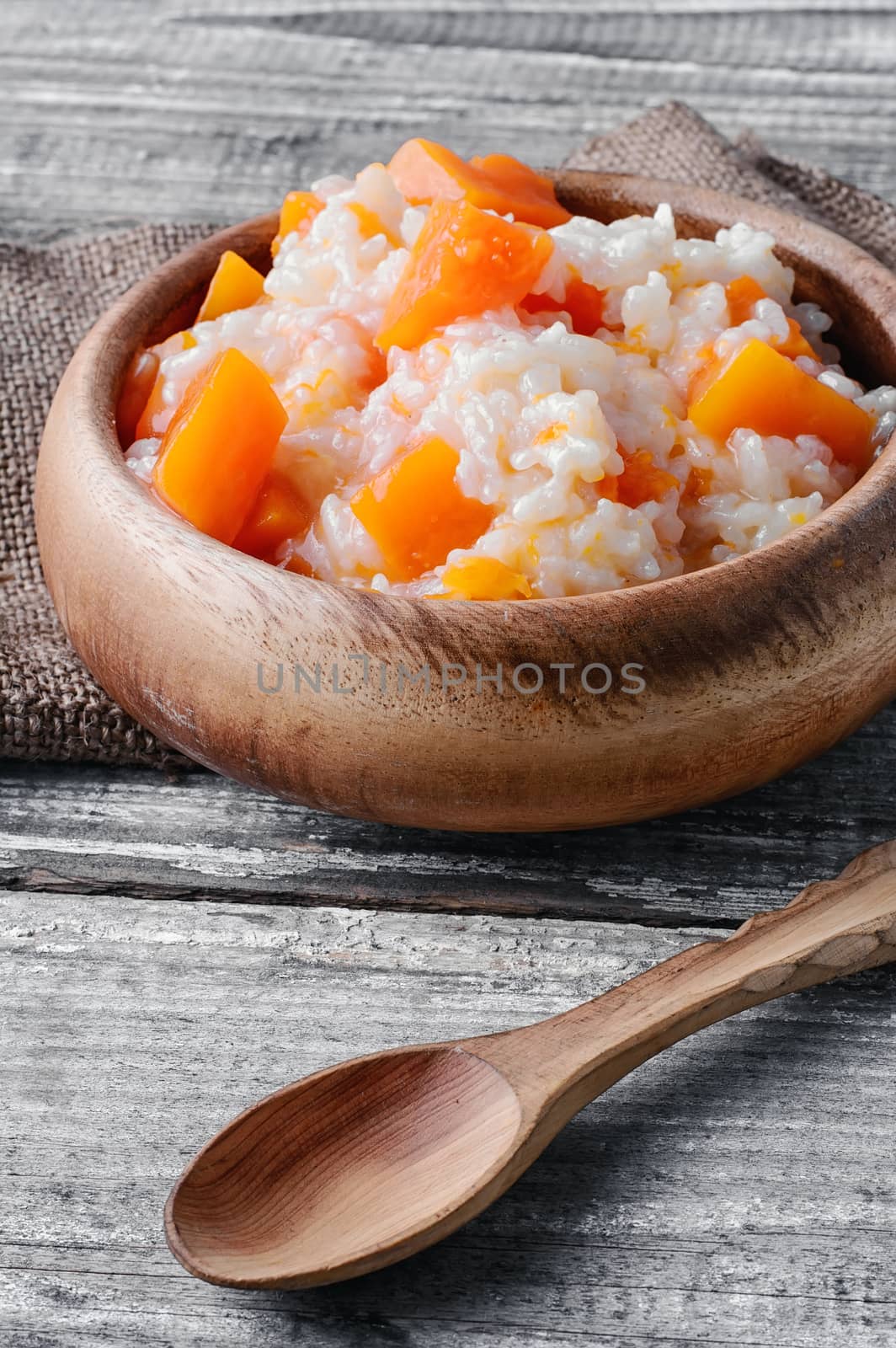 Porridge with pumpkin in a stylish wooden bowl, rustic