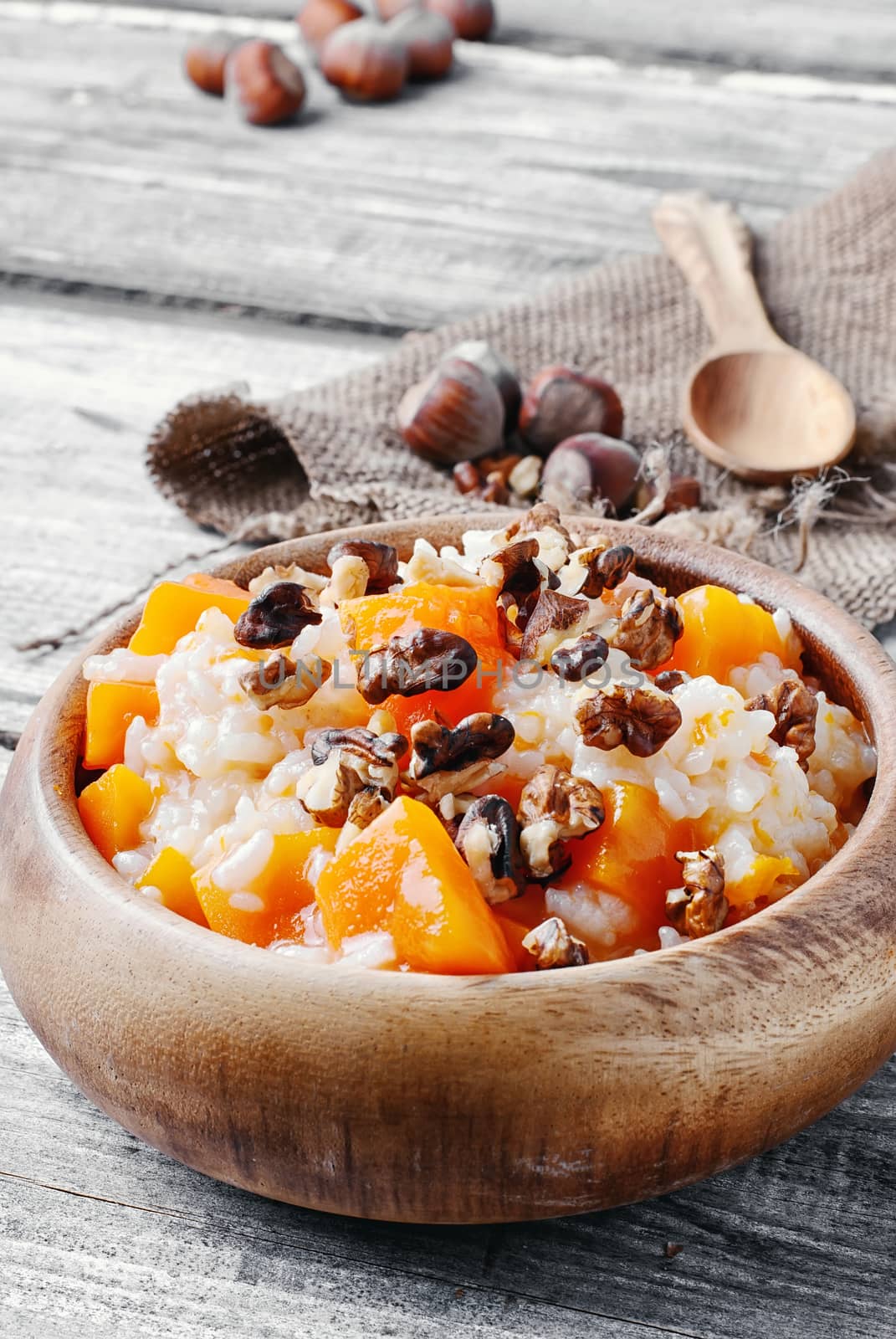 Porridge with pumpkin in a stylish wooden bowl, rustic