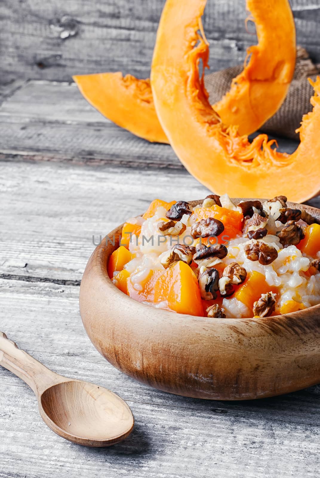 Porridge with pumpkin in a stylish wooden bowl, rustic