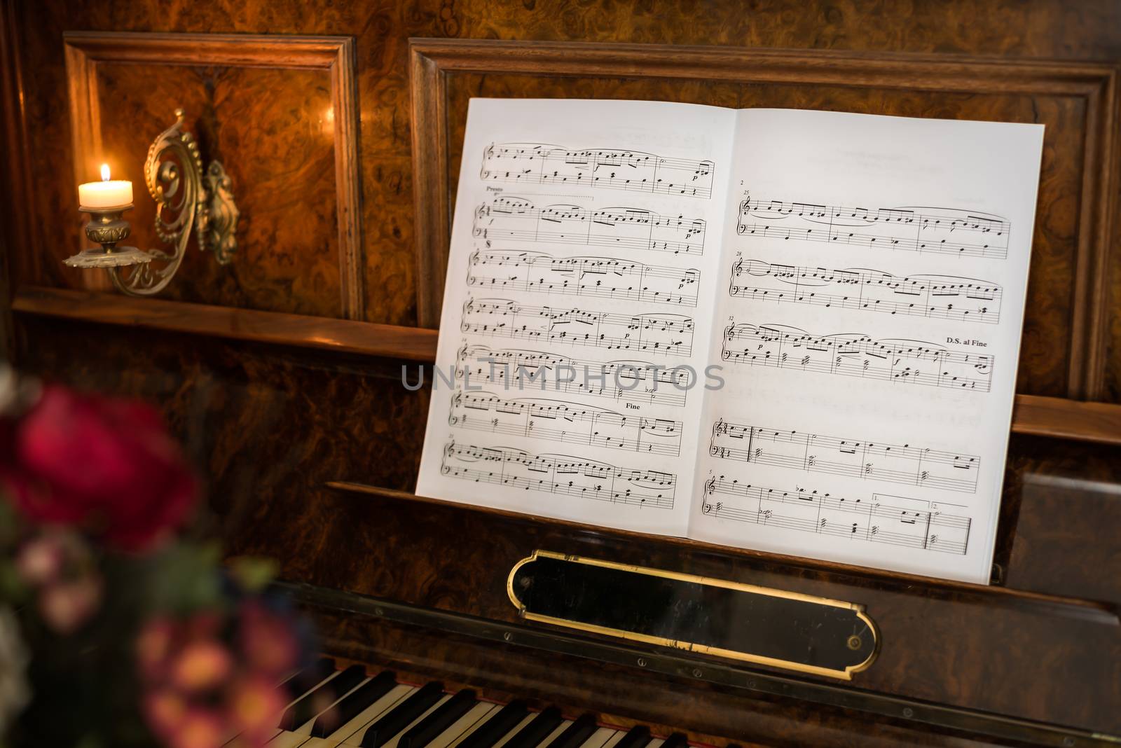 Opened Music Book on Beautiful Old Piano with Flowers in Foreground