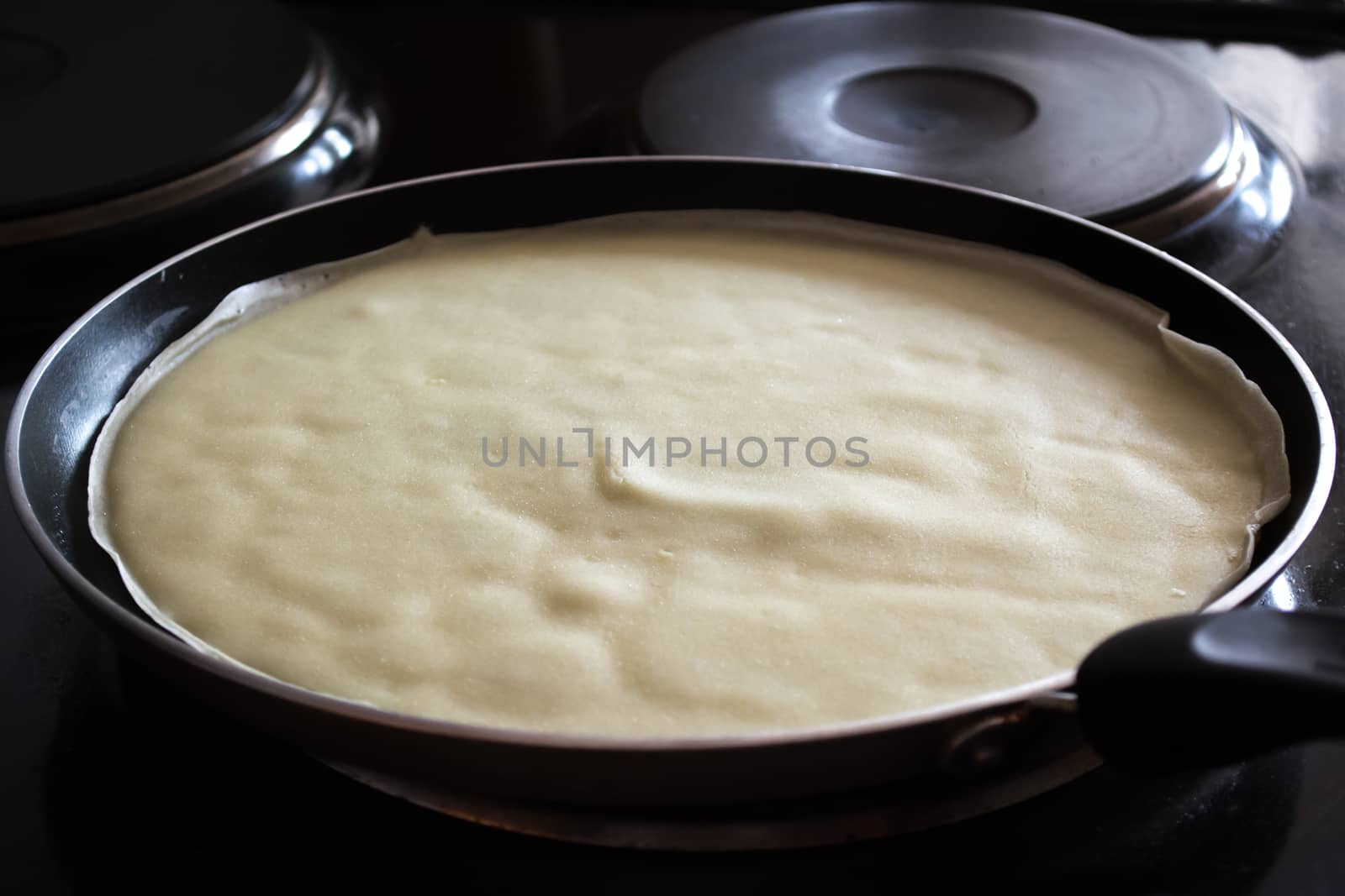 Frying pan with pancake baking on it