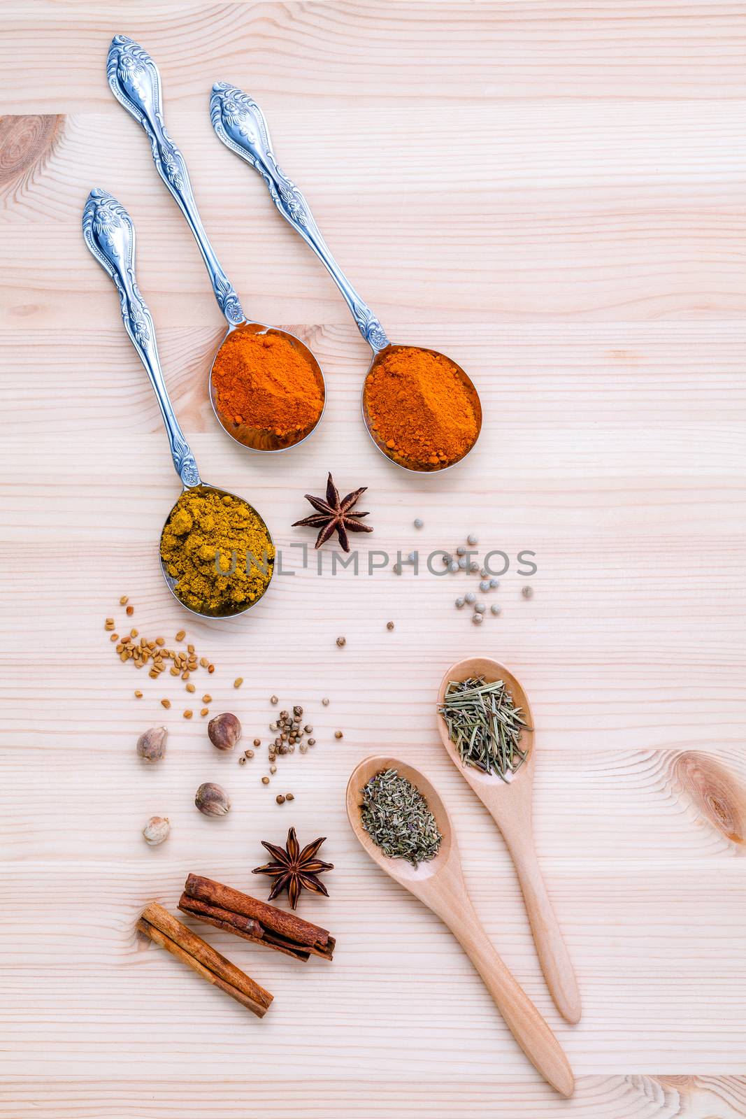 Assorted of dried spices white pepper,cumin ,cinnamon ,thyme ,chili  ,rosemary and fennel seeds with white mortar on wooden background.