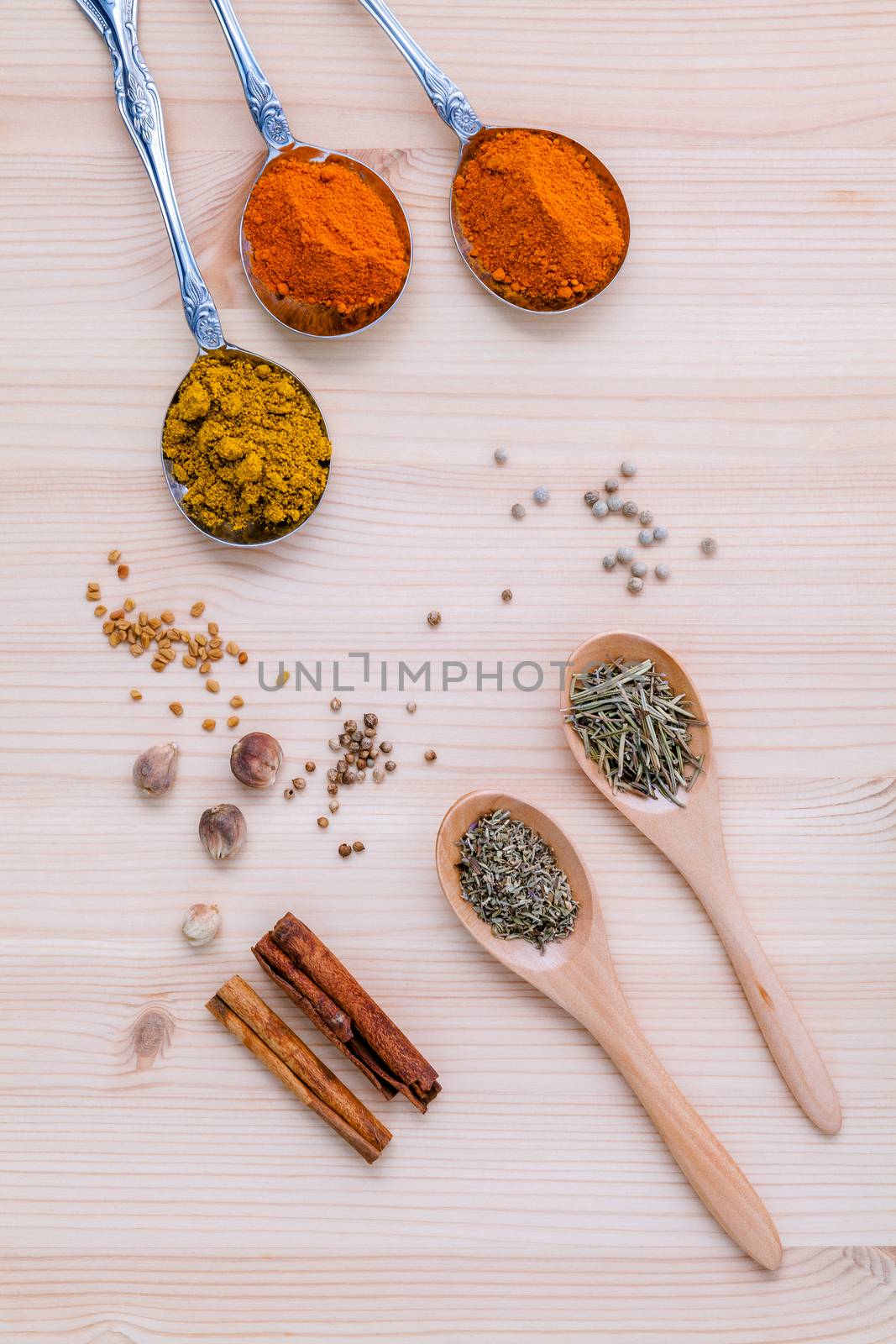 Assorted of dried spices white pepper,cumin ,cinnamon ,thyme ,chili  ,rosemary and fennel seeds with white mortar on wooden background.