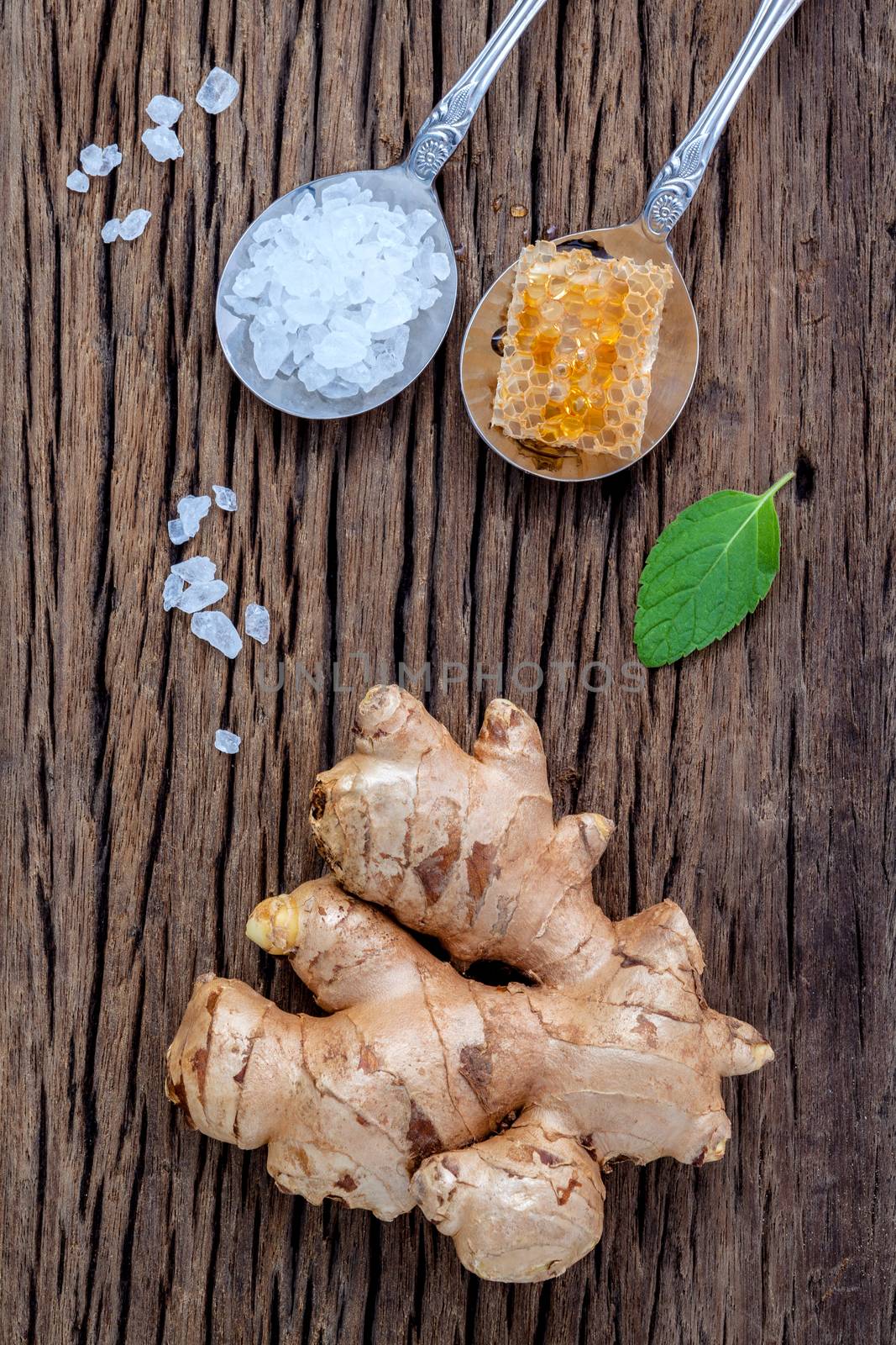 The ingredients of ginger tea with ginger roots , ginger powder , honey and peppermint on rustic wooden table.