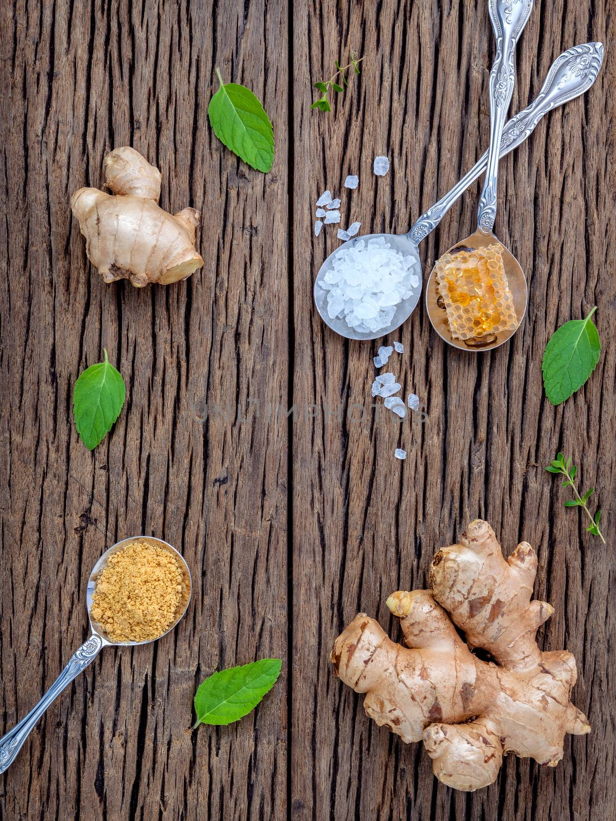 The ingredients of ginger tea with ginger roots , ginger powder , honey and peppermint on rustic wooden table.