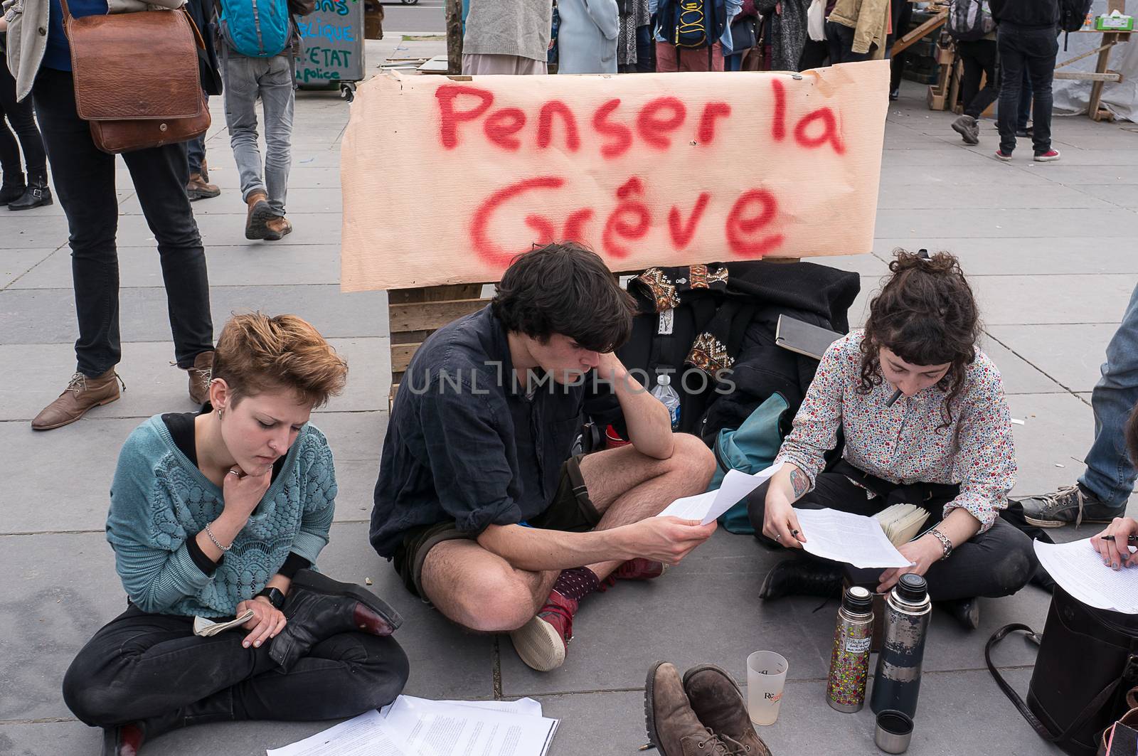 FRANCE, Paris: A picture is taken of a banner reading Thinking about striking as hundreds of militants of the Nuit Debout or Standing night movement hold a general assembly to vote about the developments of the movement at the Place de la Republique in Paris on April 3, 2016. It has been four days that hundred of people have occupied the square to show, at first, their opposition to the labour reforms in the wake of the nationwide demonstration which took place on March 31, 2016. 