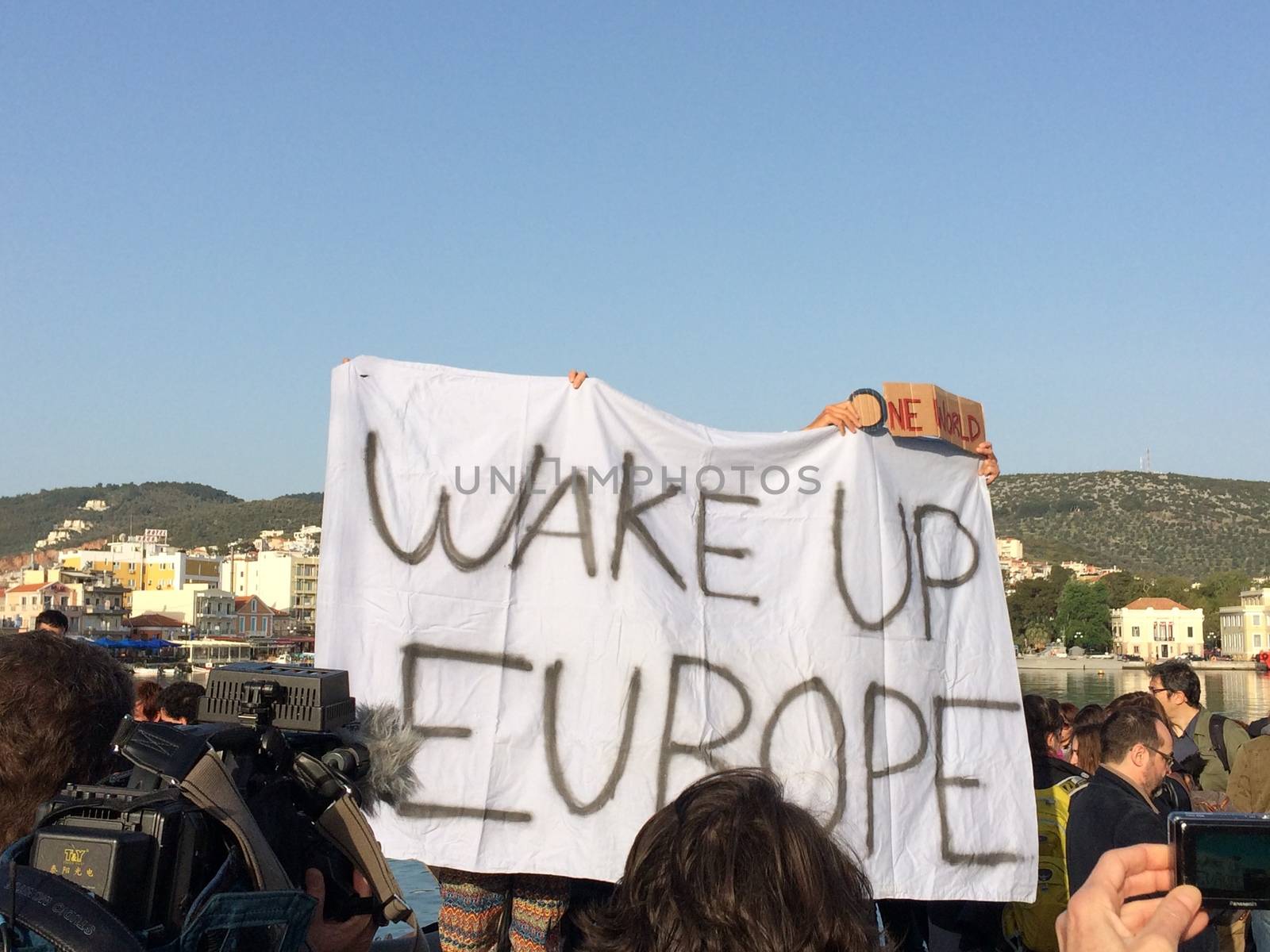 GREECE, Lesvos: A man holds a sign reading Wake up Europe at Lesvos harbour on April 4, 2016 as Greece sent a first wave of migrants back to Turkey the same day under an EU deal that has faced heavy criticism from rights groups. Under the agreement, designed to halt the main influx which comes from Turkey, all irregular migrants arriving since March 20 face being sent back, although the deal calls for each case to be examined individually. For every Syrian refugee returned, another Syrian refugee will be resettled from Turkey to the EU, with numbers capped at 72,000.