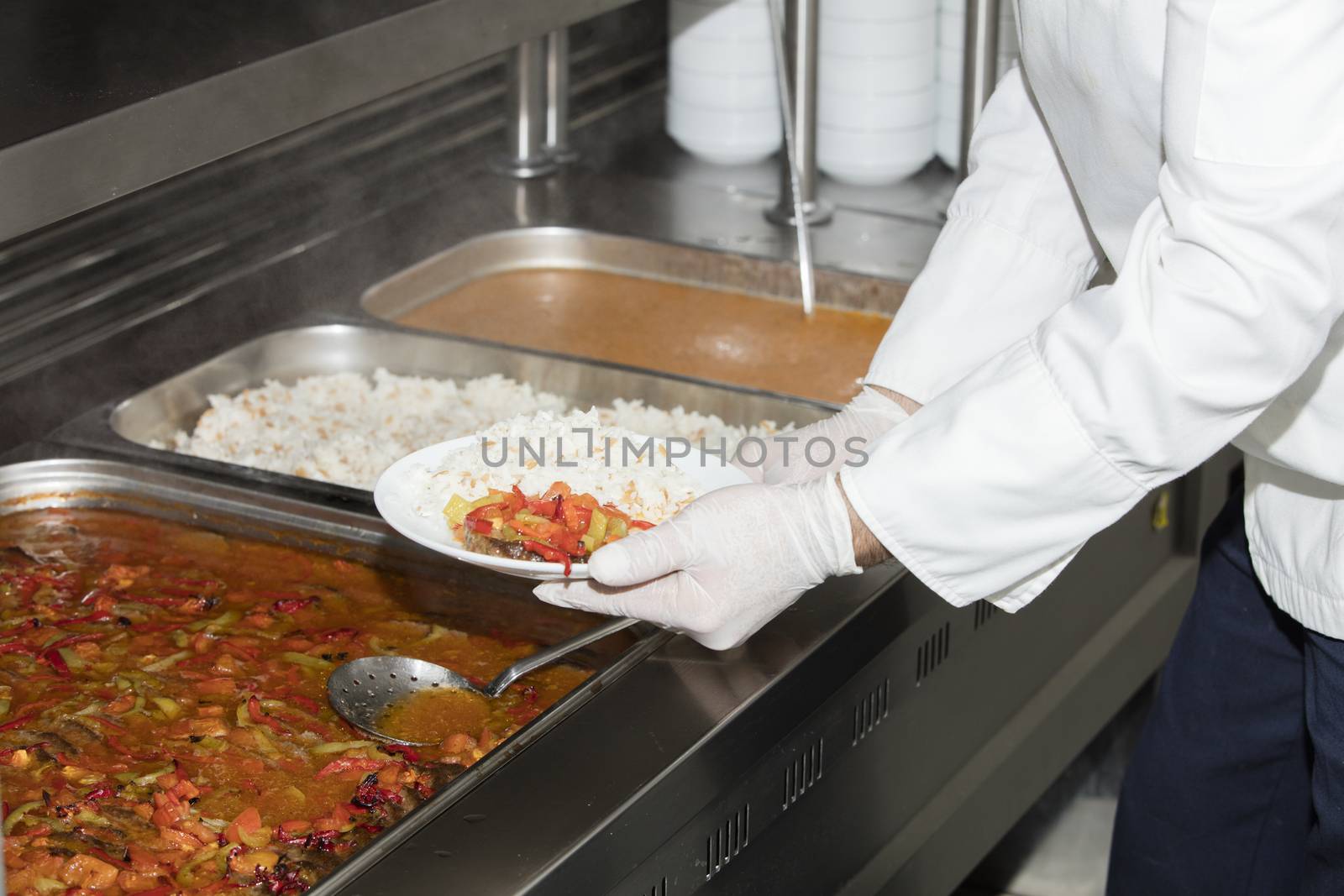 chef standing behind full lunch service station by senkaya