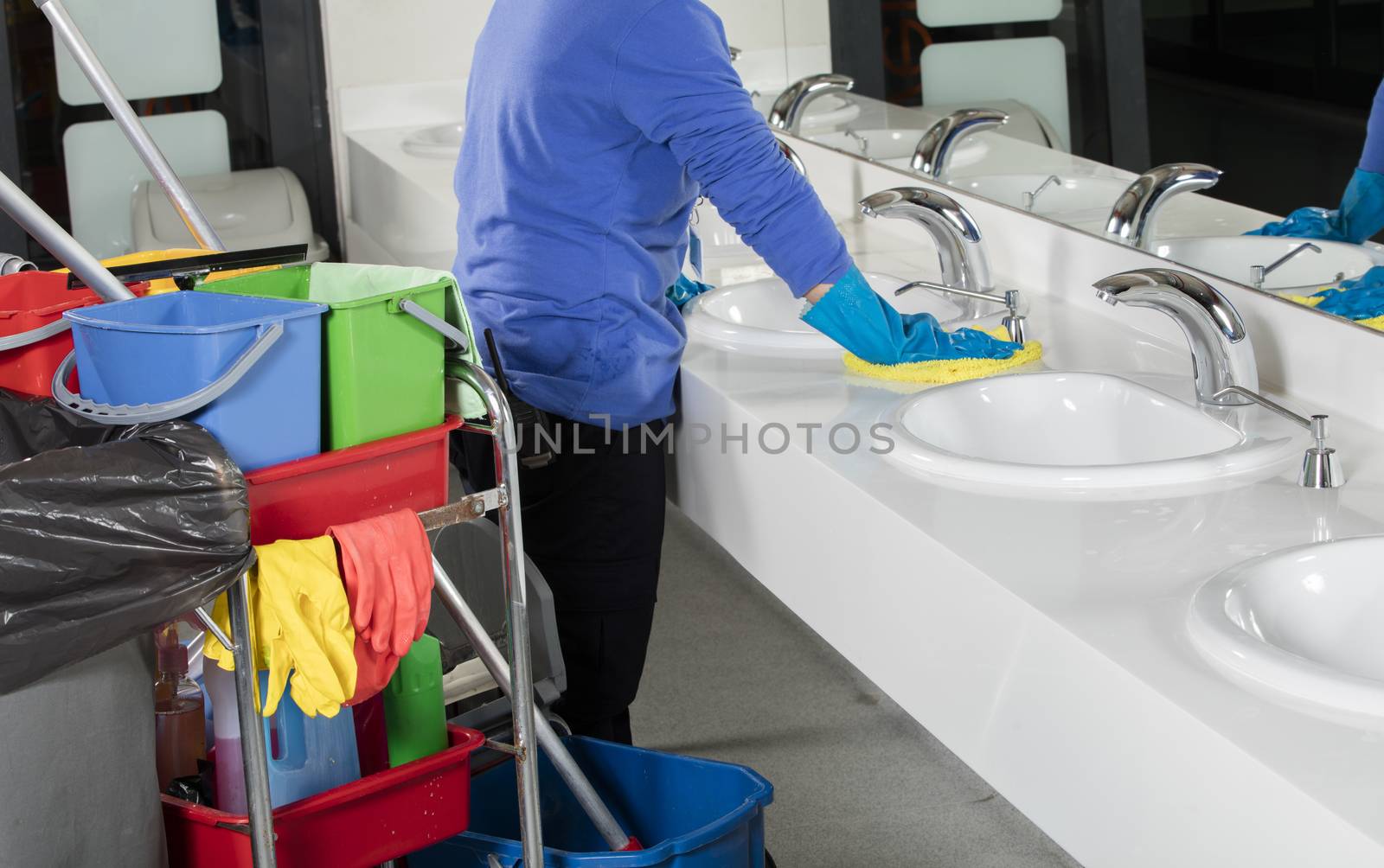 rubber gloved hand cleaning sink with duster by senkaya