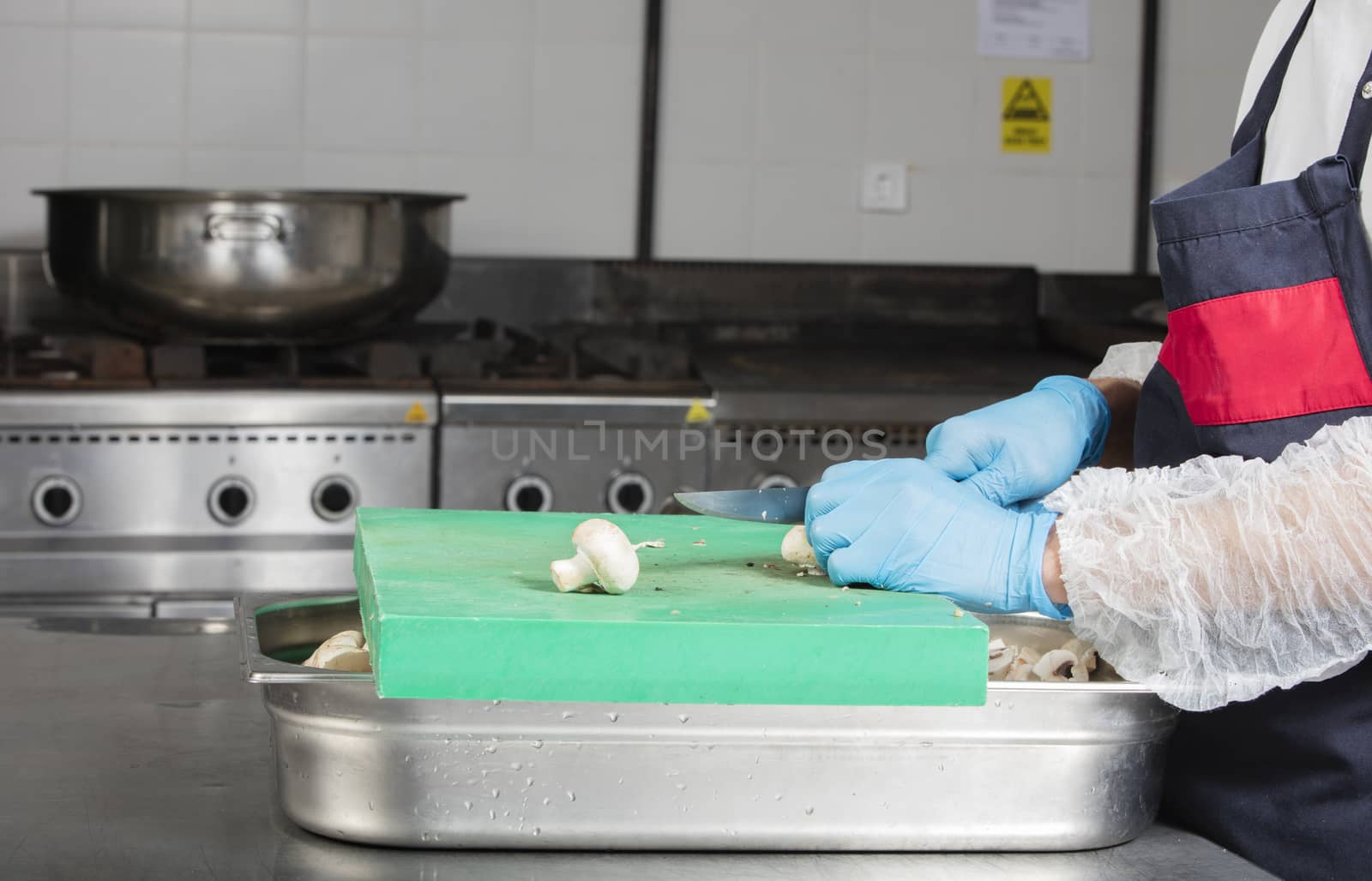 chef preparing food and cutting mushrooms in a restaurant kitchen by senkaya