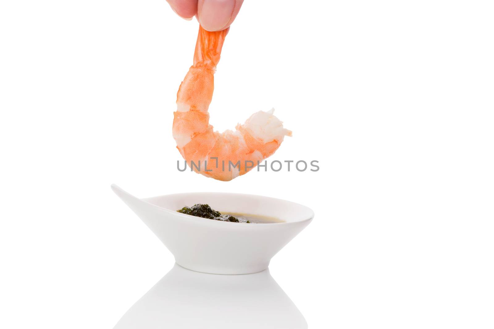 Delicious shrimp eating. Dripping cooked prawn into delicious sauce. Culinary and gourmet eating. 