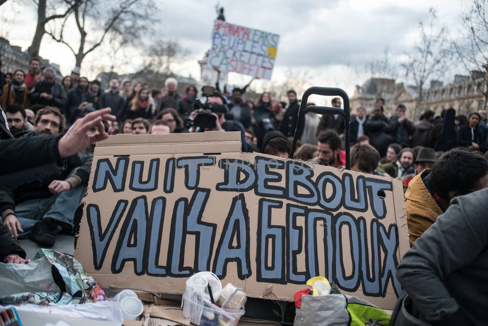 FRANCE, Paris: A picture is taken of a placard reading Standing night, Valls on his knees as hundreds of militants of the Nuit Debout or Standing night movement hold a general assembly to vote about the developments of the movement at the Place de la Republique in Paris on April 4, 2016. It has been five days that hundred of people have occupied the square to show, at first, their opposition to the labour reforms in the wake of the nationwide demonstration which took place on March 31, 2016. 