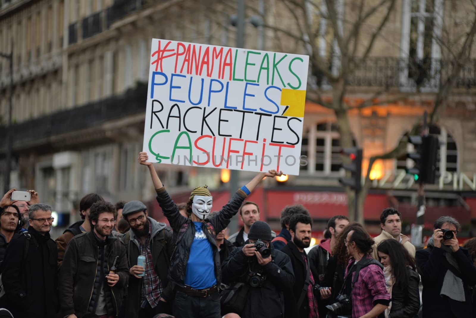 FRANCE, Paris: A man holds a placard reading #PanamaLeaks, People, Enough of extorsions referring to the massive data leak called Panama Papers as hundreds of militants of the Nuit Debout or Standing night movement hold a general assembly to vote about the developments of the movement at the Place de la Republique in Paris on April 4, 2016. It has been five days that hundred of people have occupied the square to show, at first, their opposition to the labour reforms in the wake of the nationwide demonstration which took place on March 31, 2016.