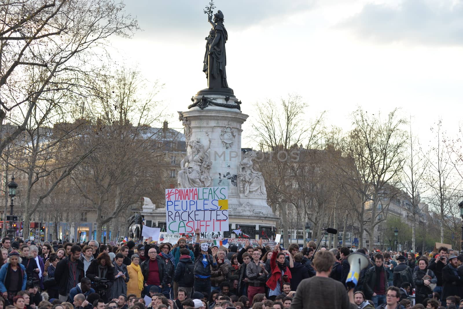 FRANCE, Paris: A man holds a placard reading #PanamaLeaks, People, Enough of extorsions referring to the massive data leak called Panama Papers as hundreds of militants of the Nuit Debout or Standing night movement hold a general assembly to vote about the developments of the movement at the Place de la Republique in Paris on April 4, 2016. It has been five days that hundred of people have occupied the square to show, at first, their opposition to the labour reforms in the wake of the nationwide demonstration which took place on March 31, 2016.