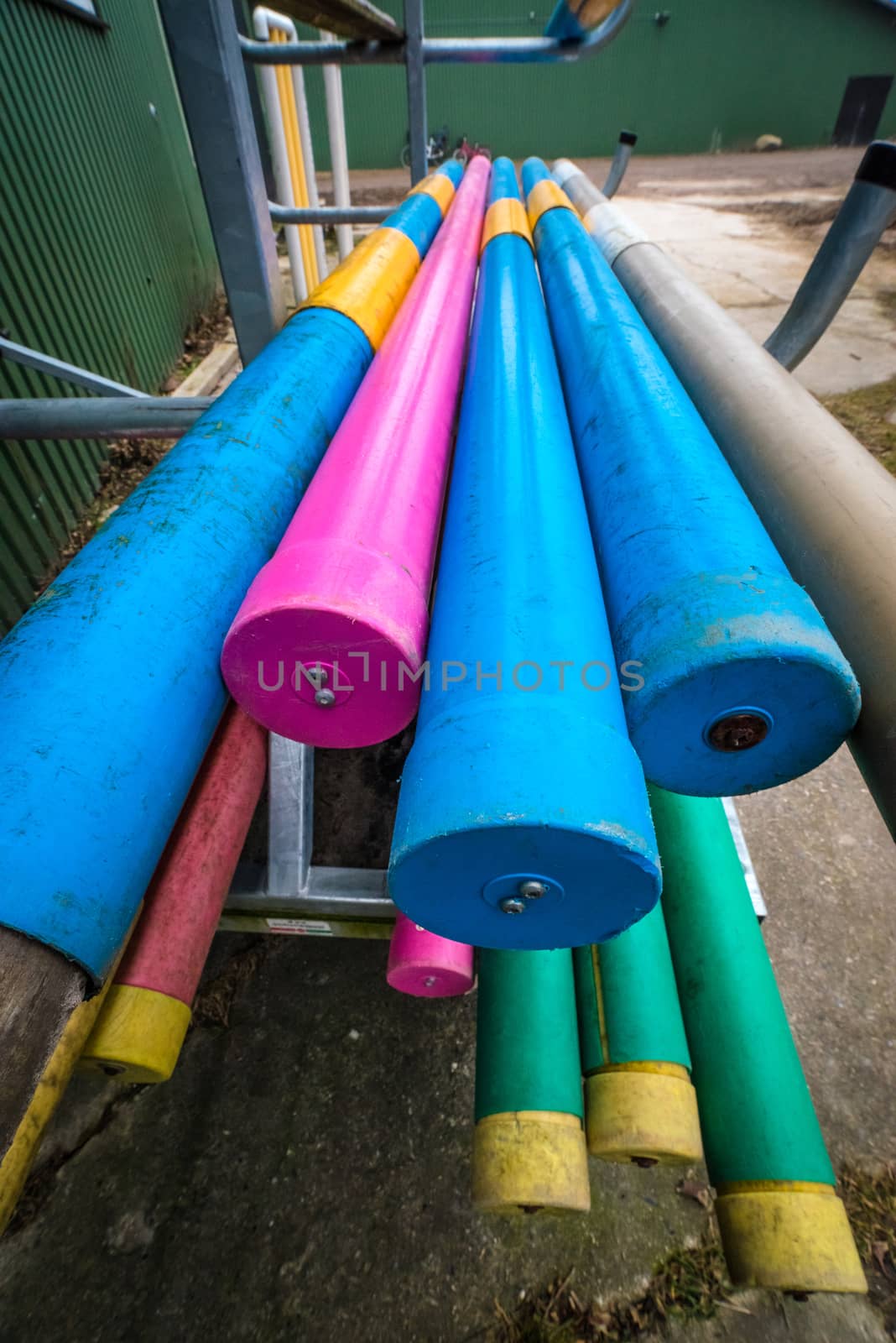 Stack of equestrian jumping poles in various colors