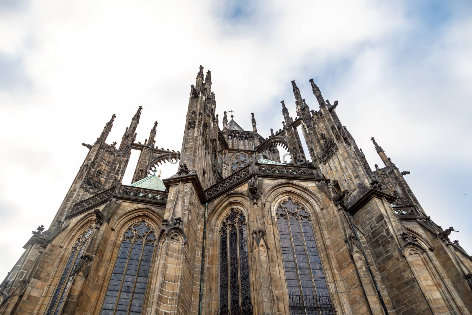 Close up detailed view of historical gothic St. Vitus Cathedral in old town of Prague, found in 1344, on cloudy blue sky background.