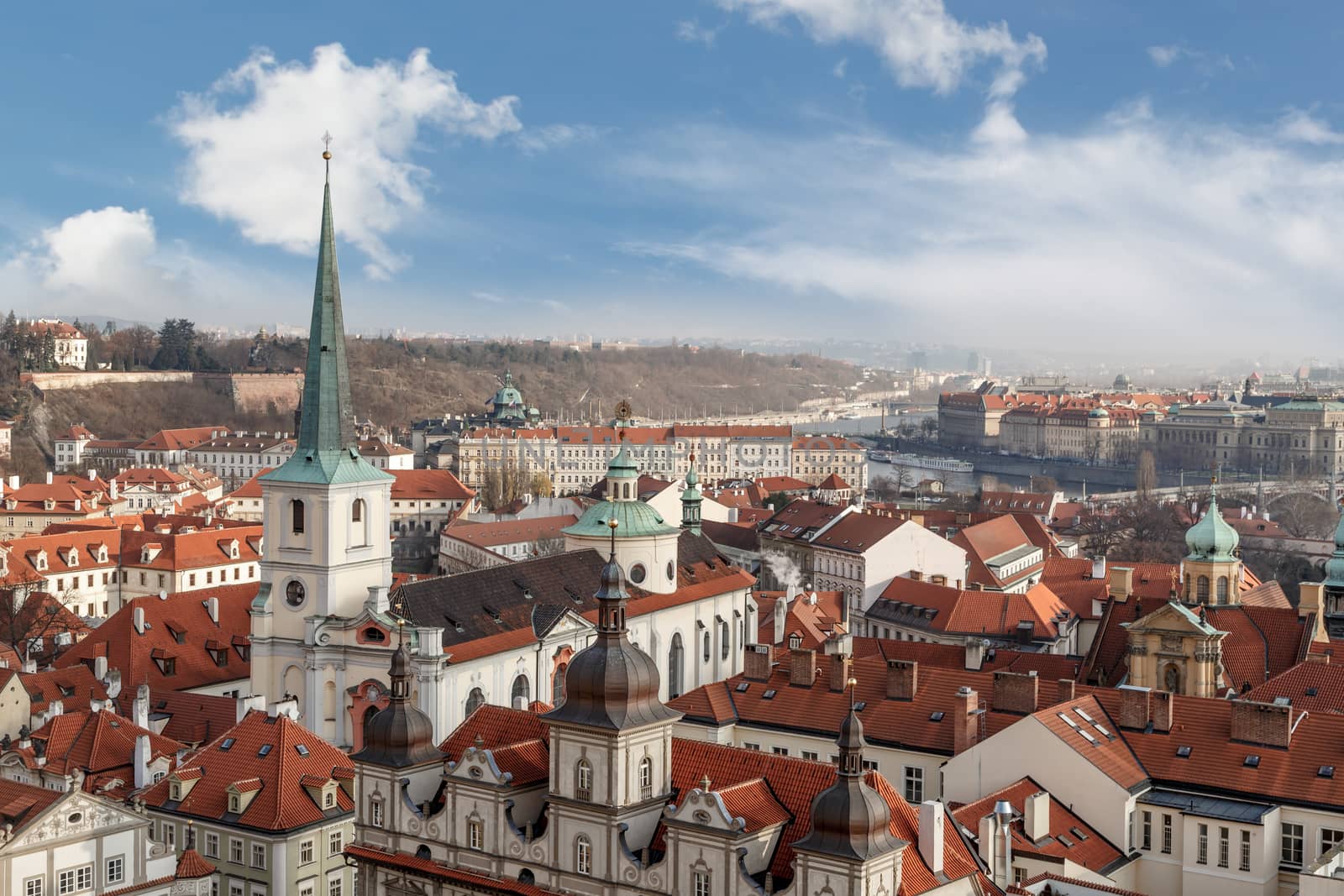 General top view of Prague cityscape view with historical gothic buildings around, on cloudy sky background.